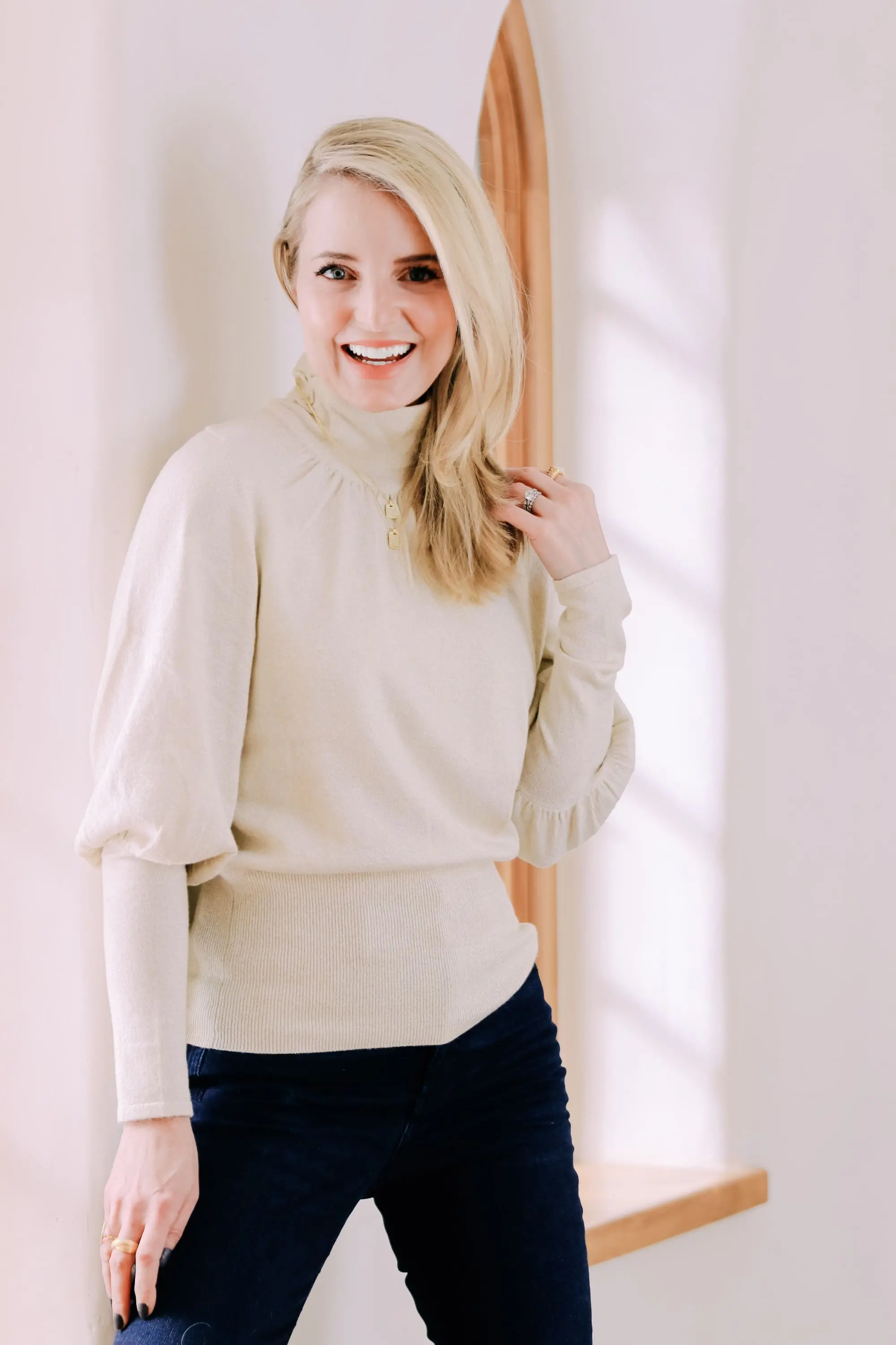 Black Friday Doorbuster, Erin Busbee of Busbee Style wearing a metallic blouson sleeve turtleneck sweater, raw step hem jeans, and cozy socks from Express in Telluride, Colorado