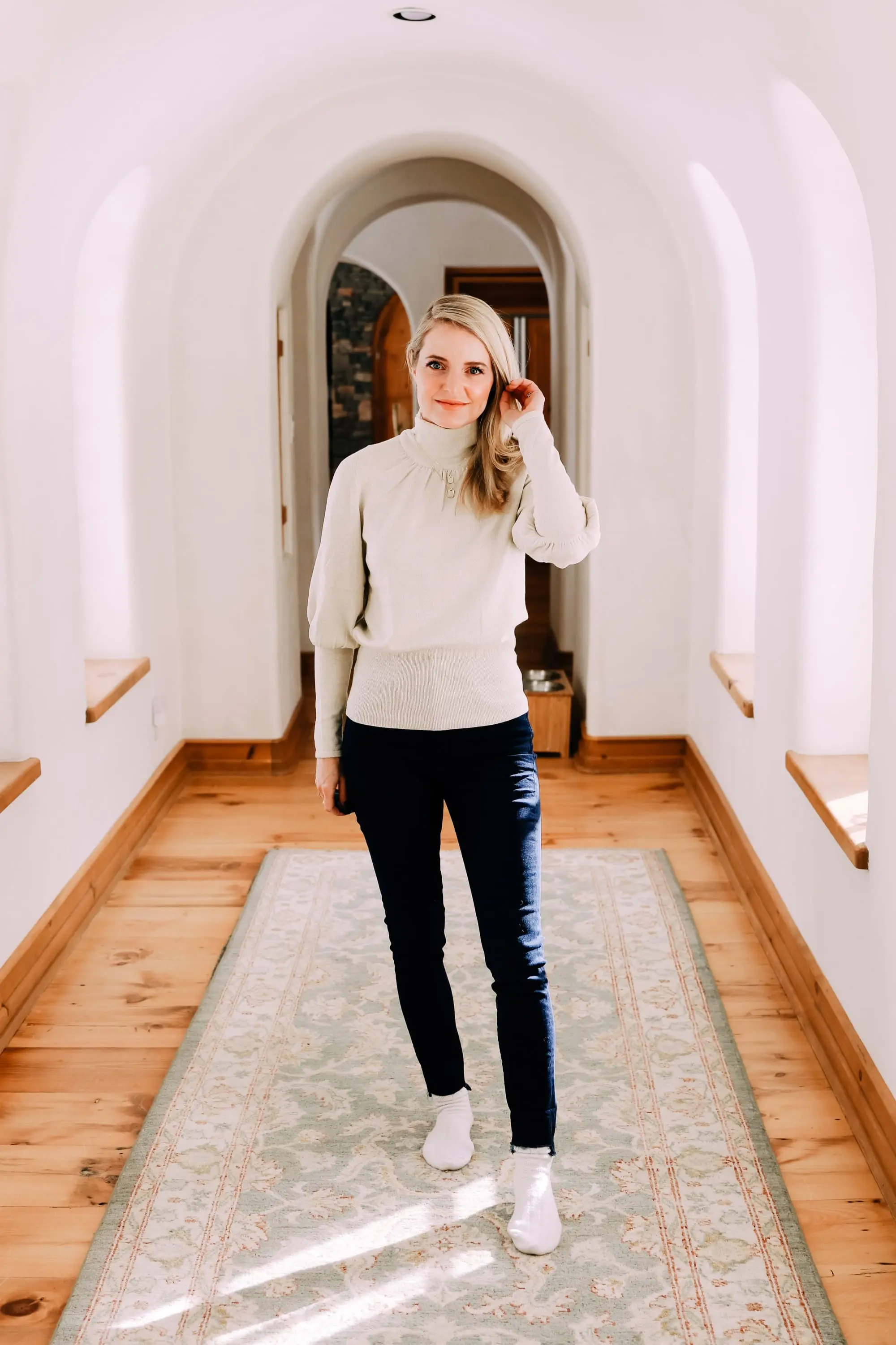 Black Friday Doorbuster, Erin Busbee of Busbee Style wearing a metallic blouson sleeve turtleneck sweater, raw step hem jeans, and cozy socks from Express in Telluride, Colorado