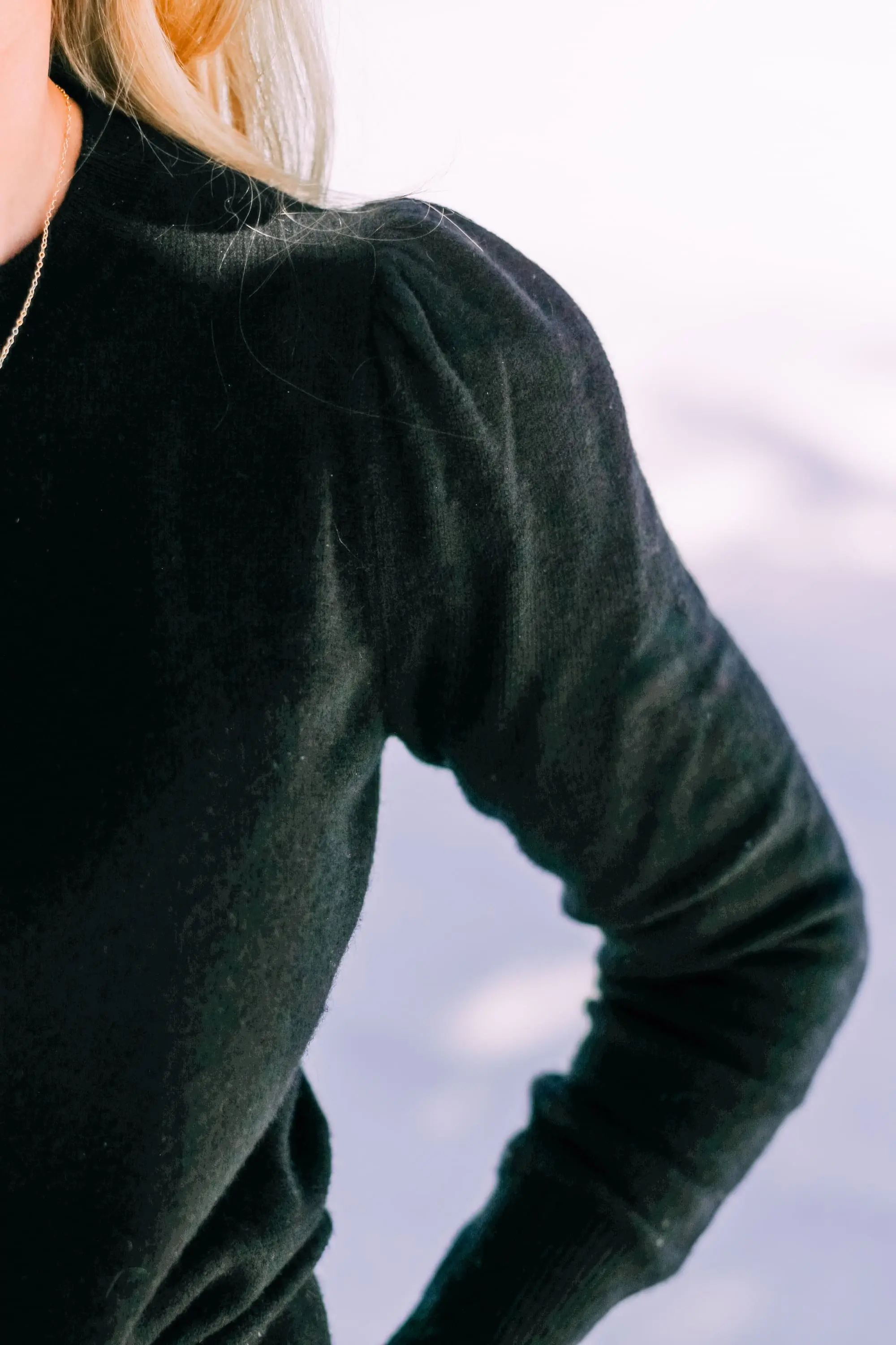 Thoughtful Gifts, Erin Busbee of Busbee Style wearing a black puff sleeve cashmere sweater by AQUA, gray wash Agolde jeans, black Sorel boots, and a diamond star necklace by Marc & Marcella from Bloomingdale's in Telluride, Colorado