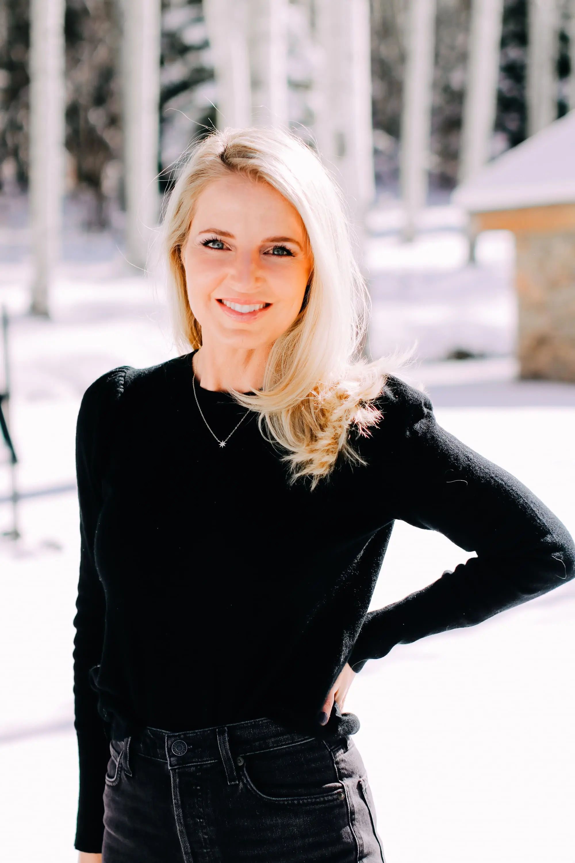 Thoughtful Gifts, Erin Busbee of Busbee Style wearing a black puff sleeve cashmere sweater by AQUA, gray wash Agolde jeans, black Sorel boots, and a diamond star necklace by Marc & Marcella from Bloomingdale's in Telluride, Colorado