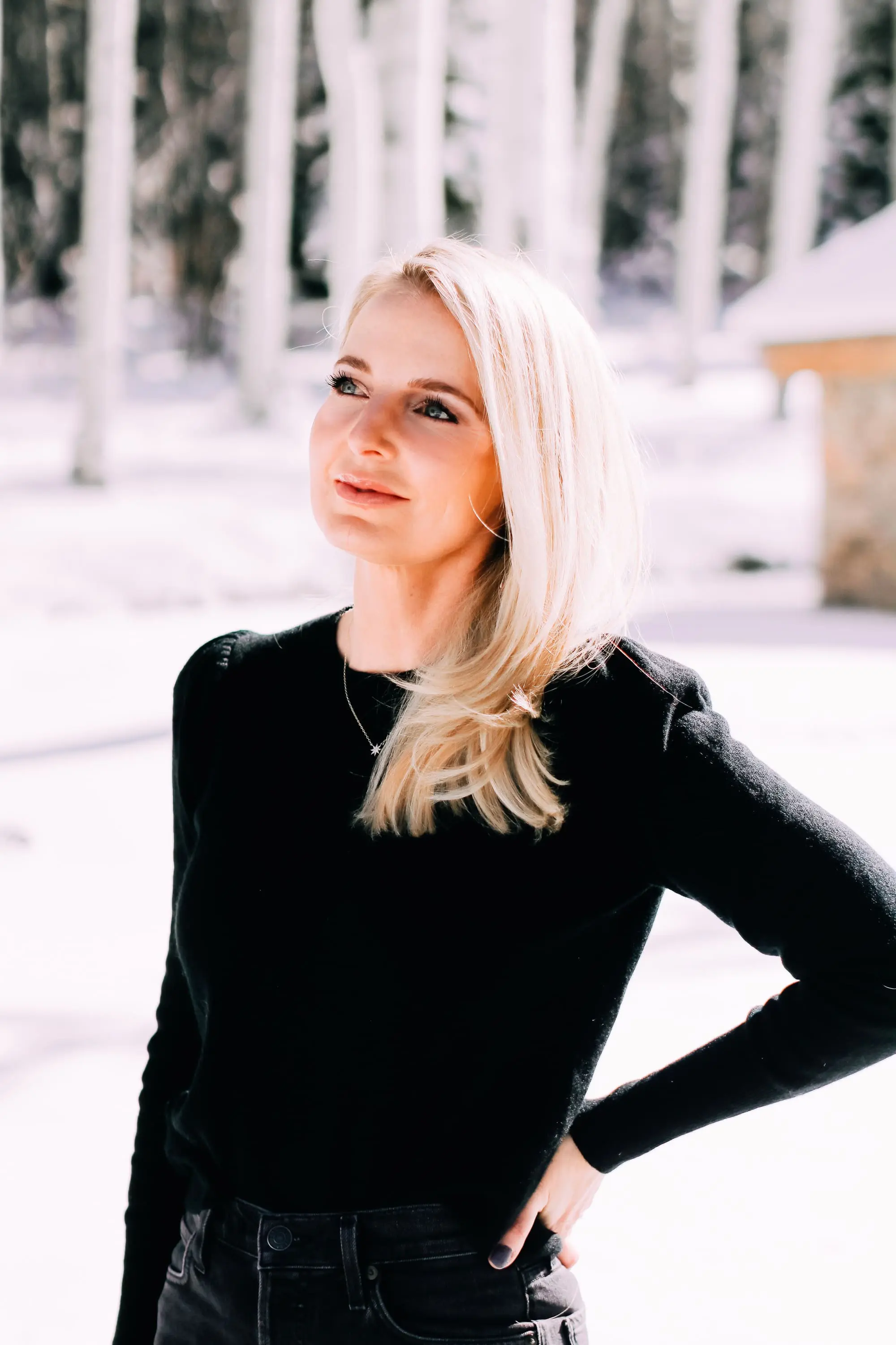 Thoughtful Gifts, Erin Busbee of Busbee Style wearing a black puff sleeve cashmere sweater by AQUA, gray wash Agolde jeans, black Sorel boots, and a diamond star necklace by Marc & Marcella from Bloomingdale's in Telluride, Colorado