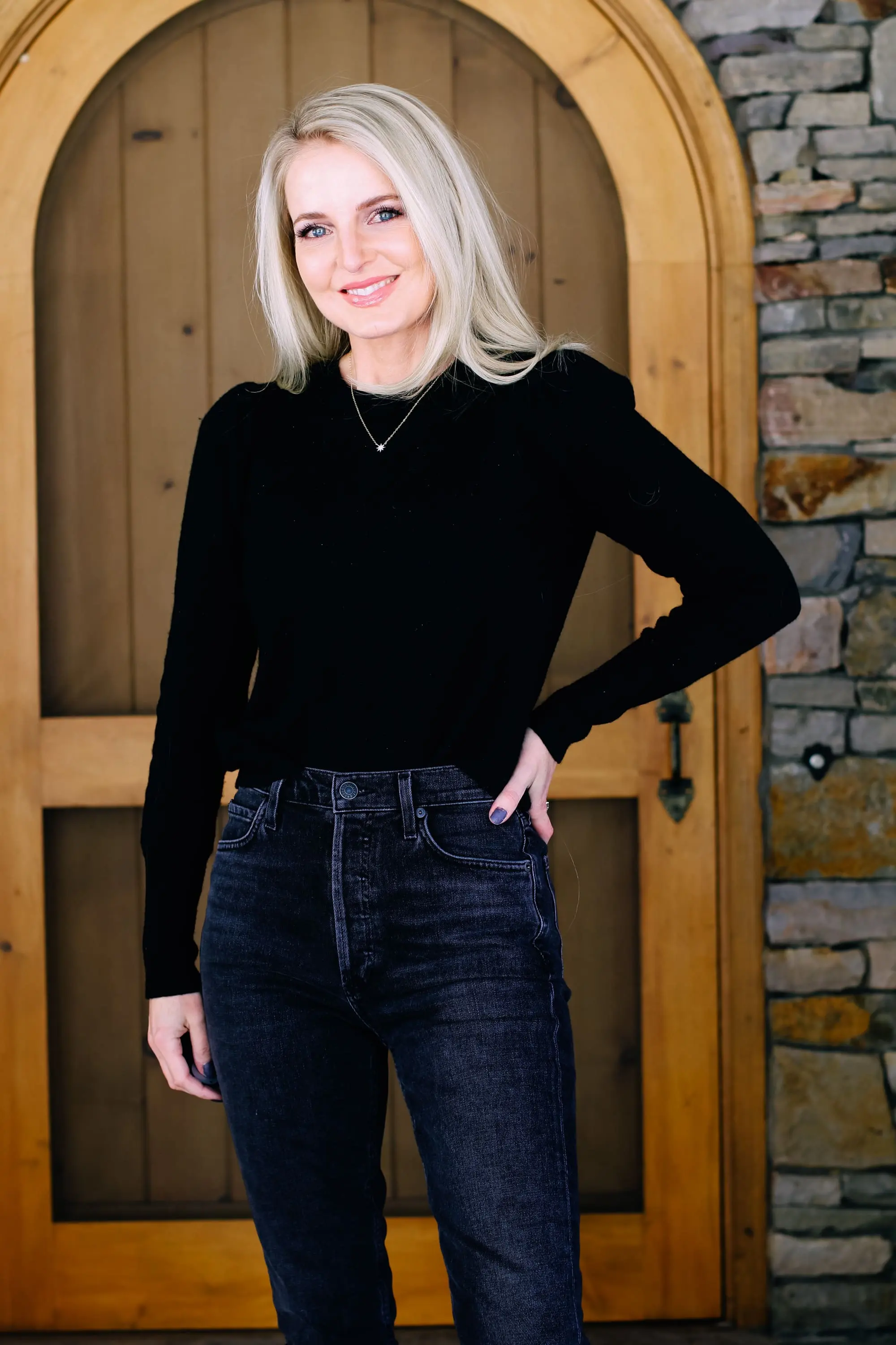 Thoughtful Gifts, Erin Busbee of Busbee Style wearing a black puff sleeve cashmere sweater by AQUA, gray wash Agolde jeans, black Sorel boots, and a diamond star necklace by Marc & Marcella from Bloomingdale's in Telluride, Colorado