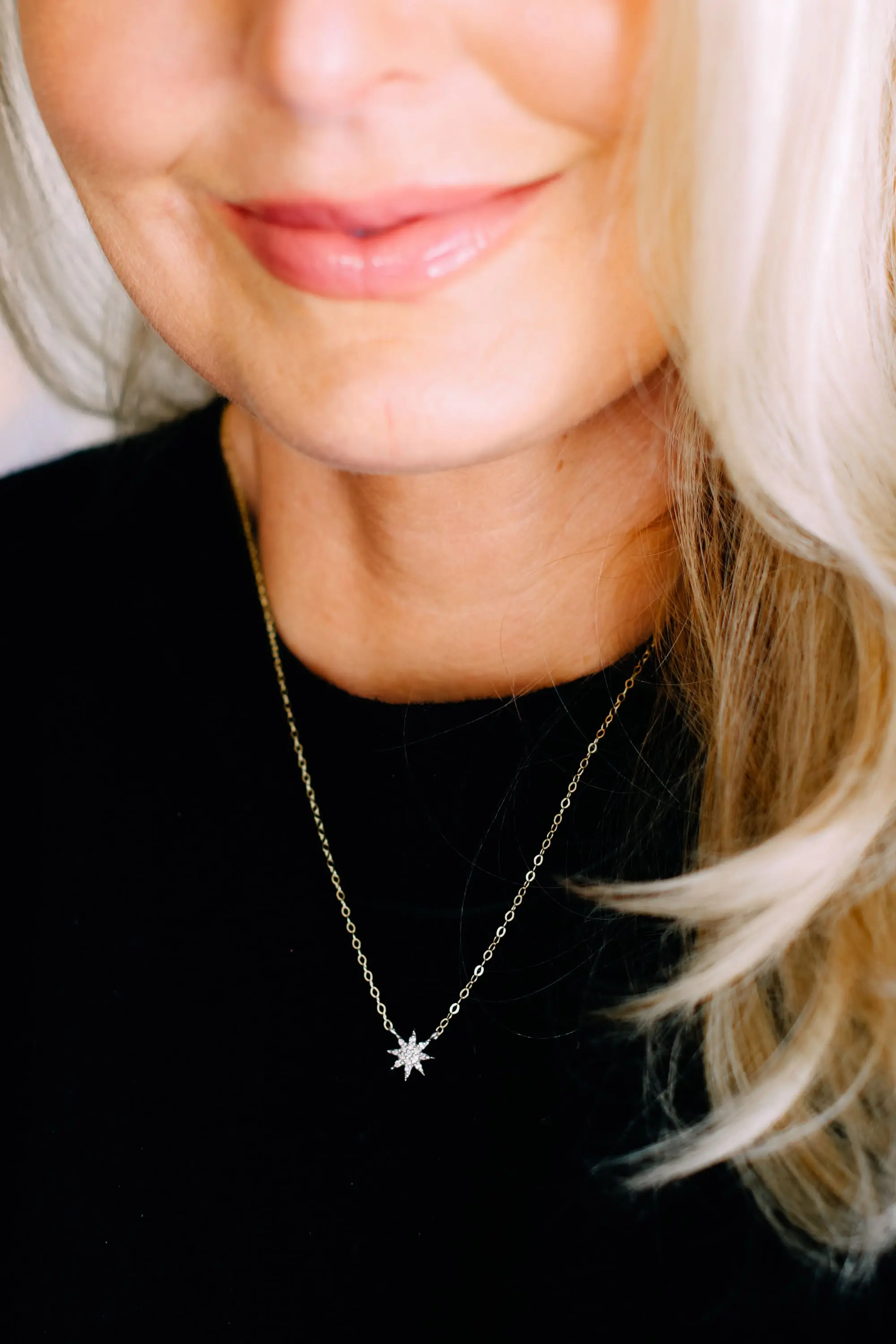 Thoughtful Gifts, Erin Busbee of Busbee Style wearing a black puff sleeve cashmere sweater by AQUA, gray wash Agolde jeans, black Sorel boots, and a diamond star necklace by Marc & Marcella from Bloomingdale's in Telluride, Colorado