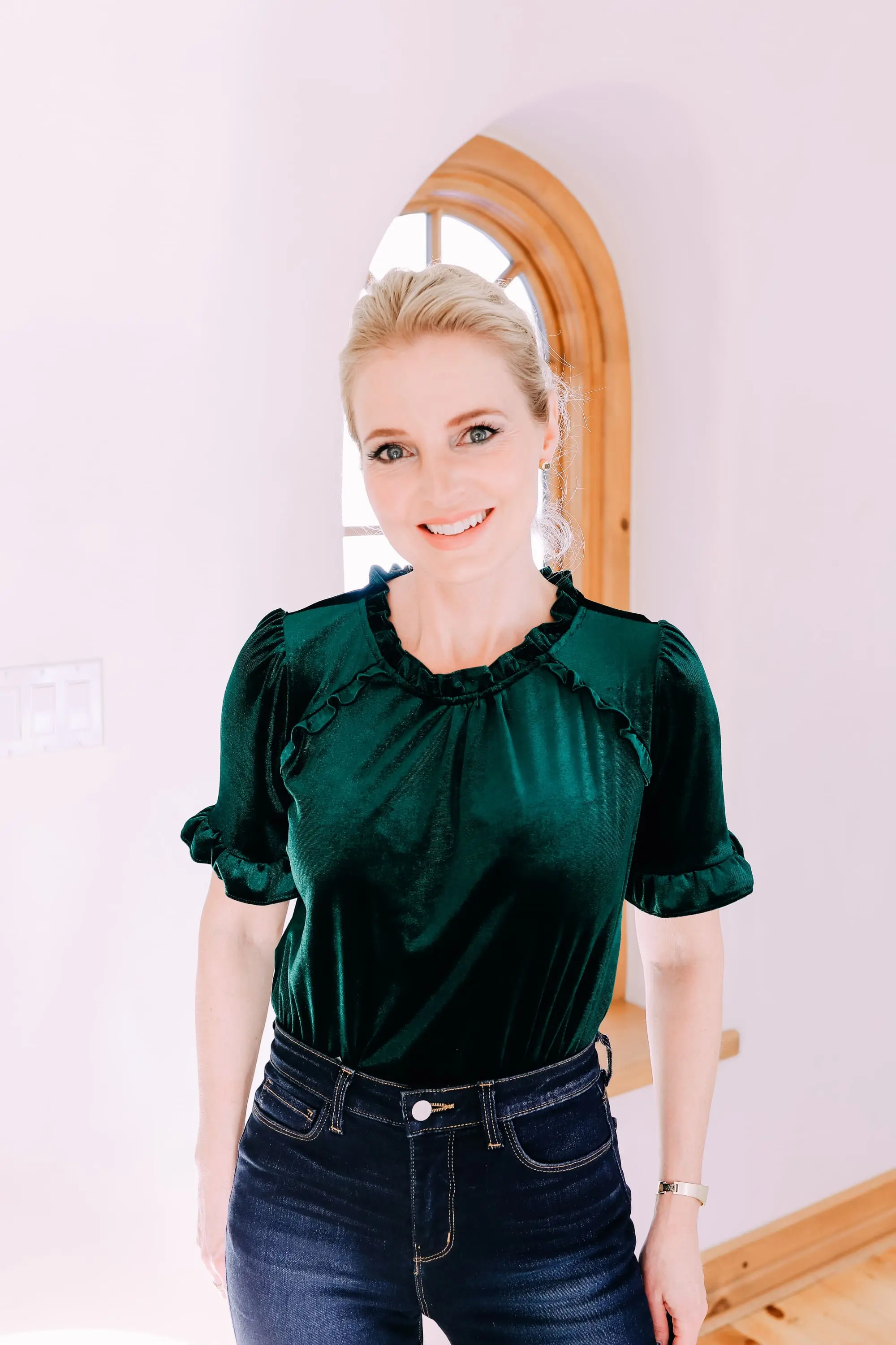 Holiday Outfits With Jeans, Erin Busbee of Busbee Style wearing a green velvet ruffle sleeve blouse by Gibson, L'Agence dark wash skinny jeans, and black Jimmy Choo Romy pumps from Nordstrom in Telluride, Colorado