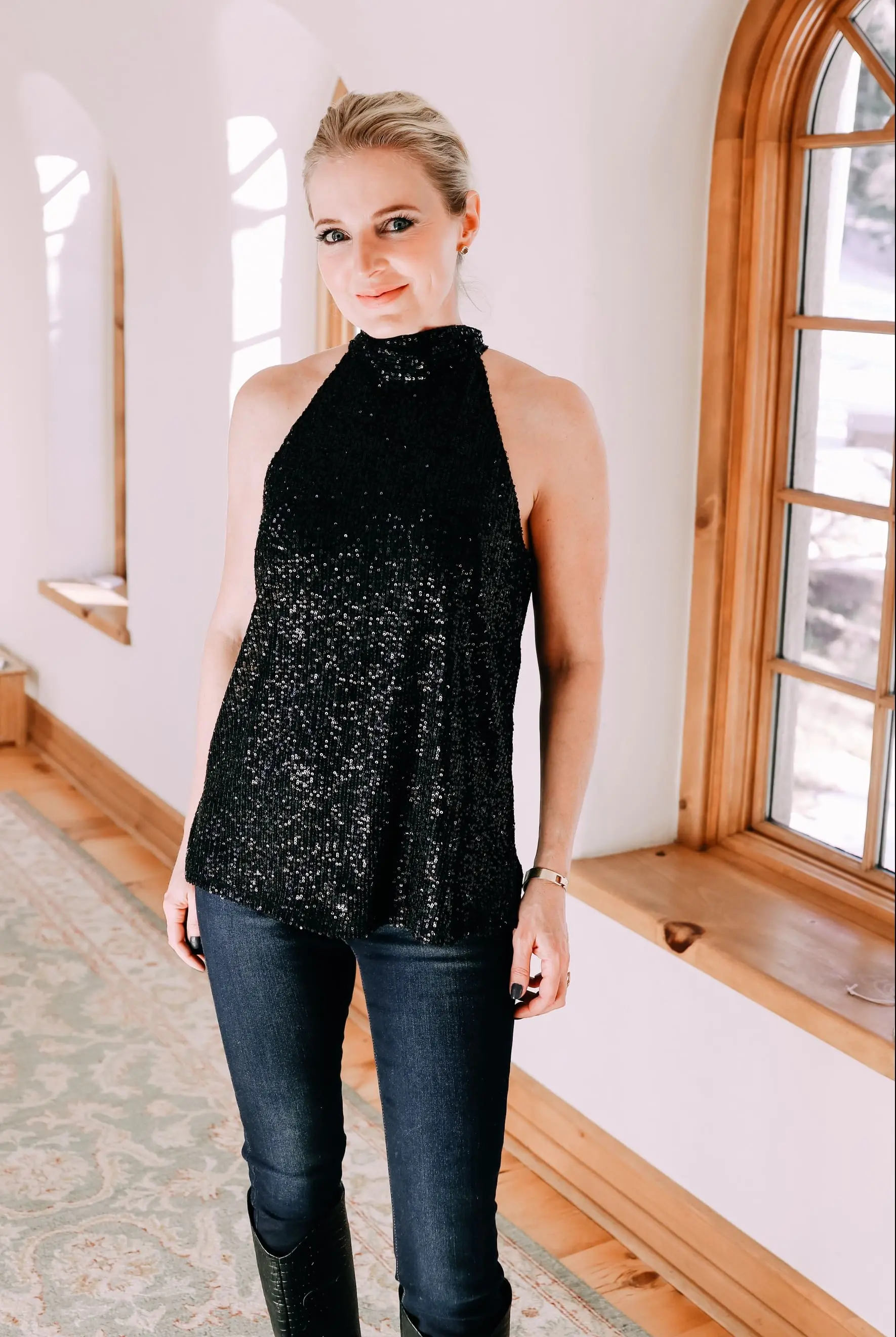 Holiday Outfits With Jeans, Erin Busbee of Busbee Style wearing a black sequin halter neck blouse by Chelsea28, L'Agence dark wash skinny jeans, and black snake embossed boots by Schutz from Nordstrom in Telluride, Colorado