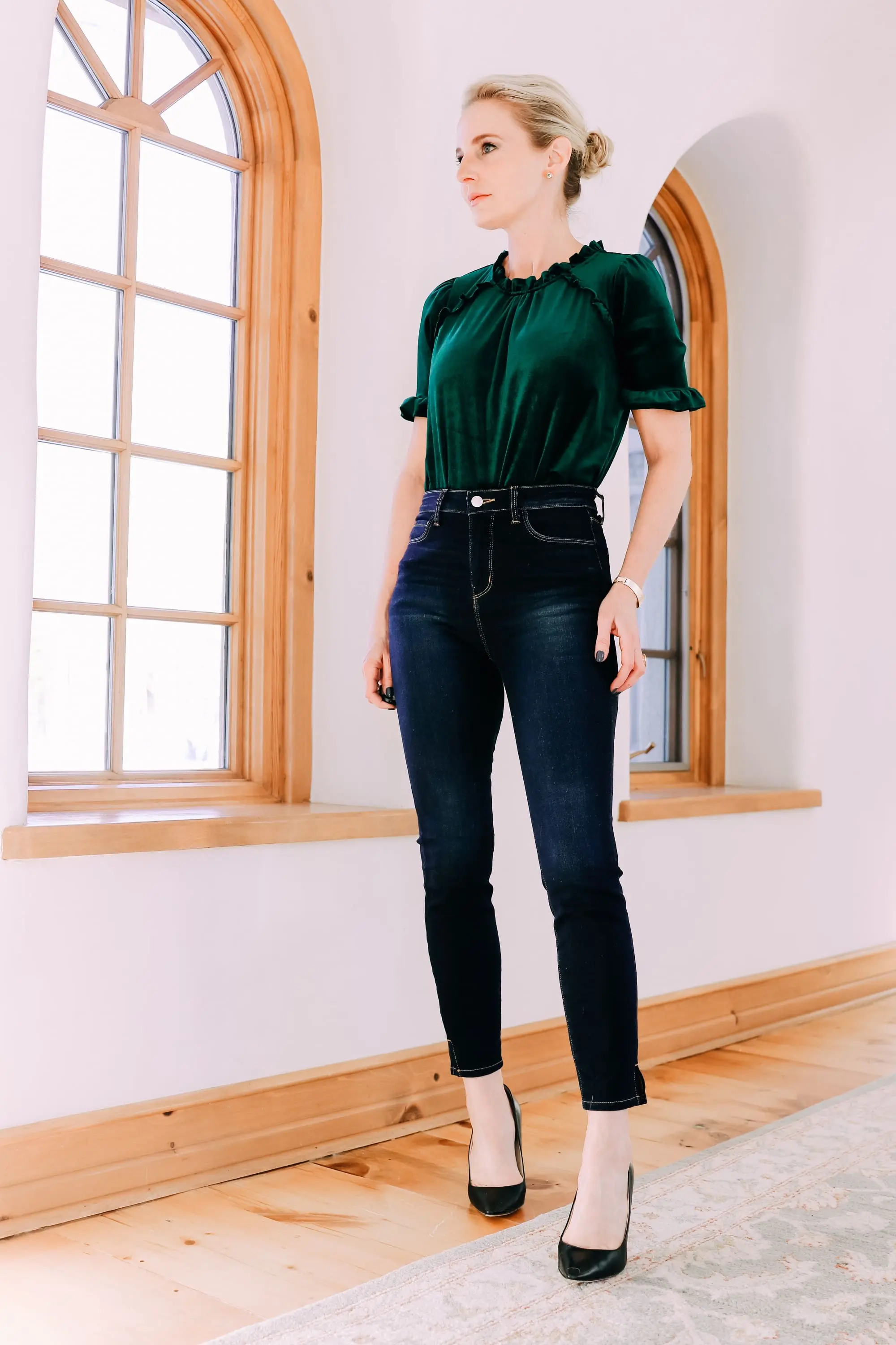 Holiday Outfits With Jeans, Erin Busbee of Busbee Style wearing a green velvet ruffle sleeve blouse by Gibson, L'Agence dark wash skinny jeans, and black Jimmy Choo Romy pumps from Nordstrom in Telluride, Colorado