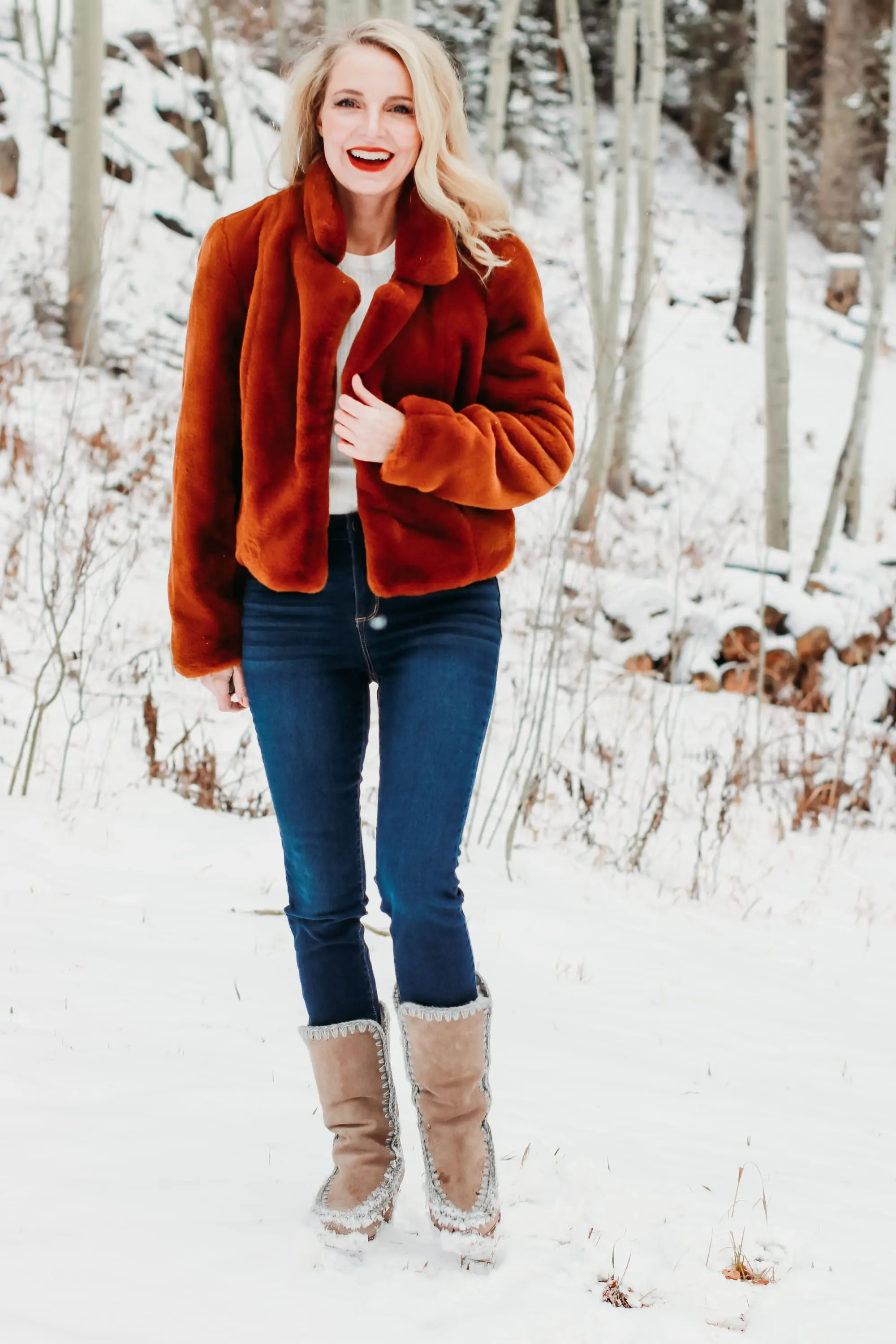 How to Wear Faux fur coat, Erin Busbee of Busbee Style wearing a brwon Blank NYC faux fur jacket with ribbed ruched sleeve sweater and dark wash skinny jeans from Express and Mou woven snow boots standing in the snow in Telluride, Colorado