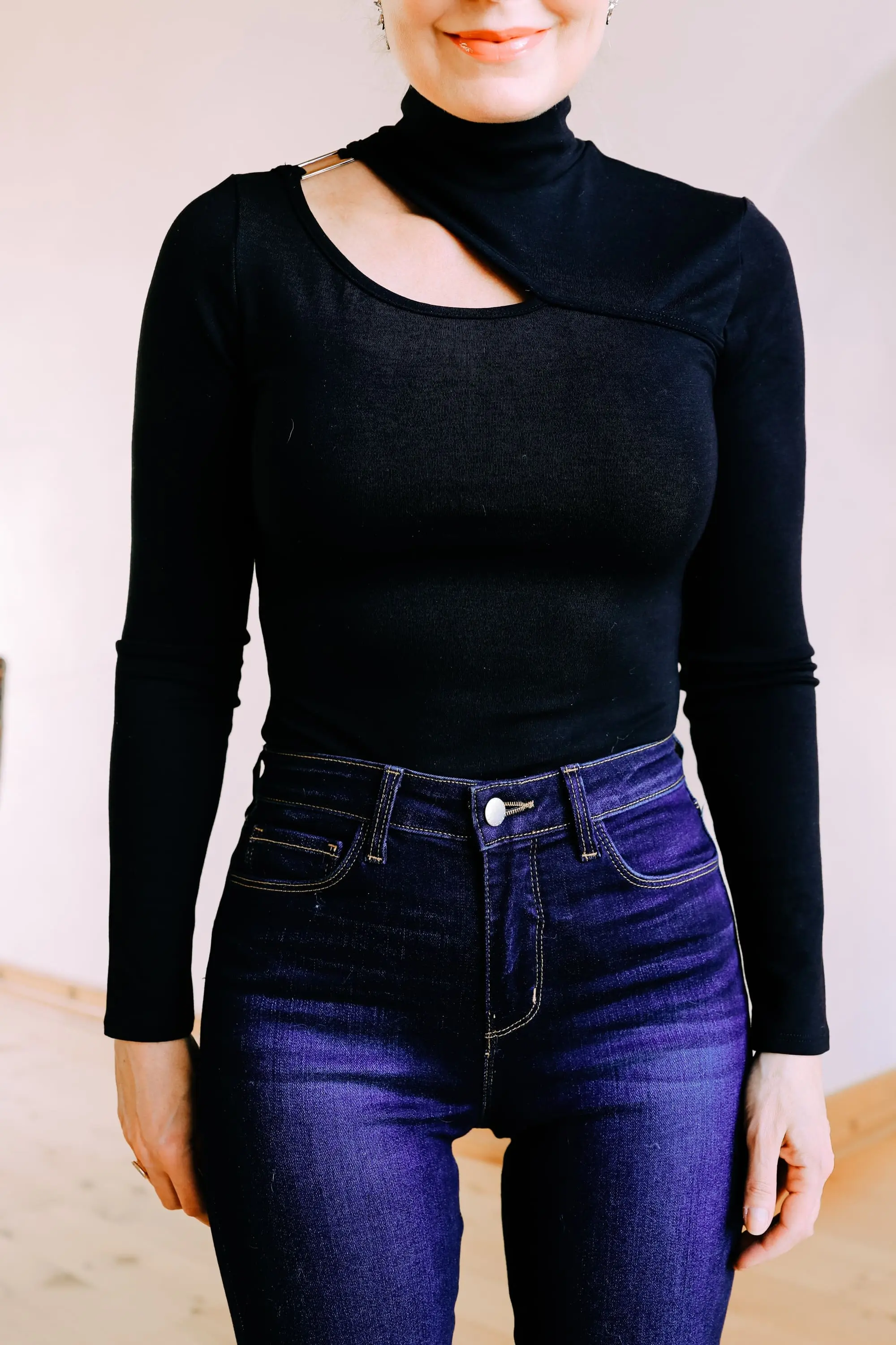 Holiday outfit ideas featuring black turtleneck with cutout and dark wash skinny jeans on fashion over 40 blogger Erin Busbee, look sexy and sophisticated at any age