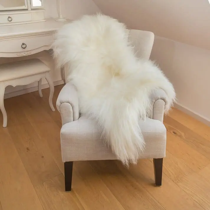 How to choose the perfect rug for your space featuring a pelt rug draped over a chair that could also be used a rug over carpet
