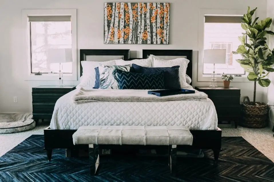 How To Choose The Perfect Rug For Your Space with colorful blue rug placed partially under bed