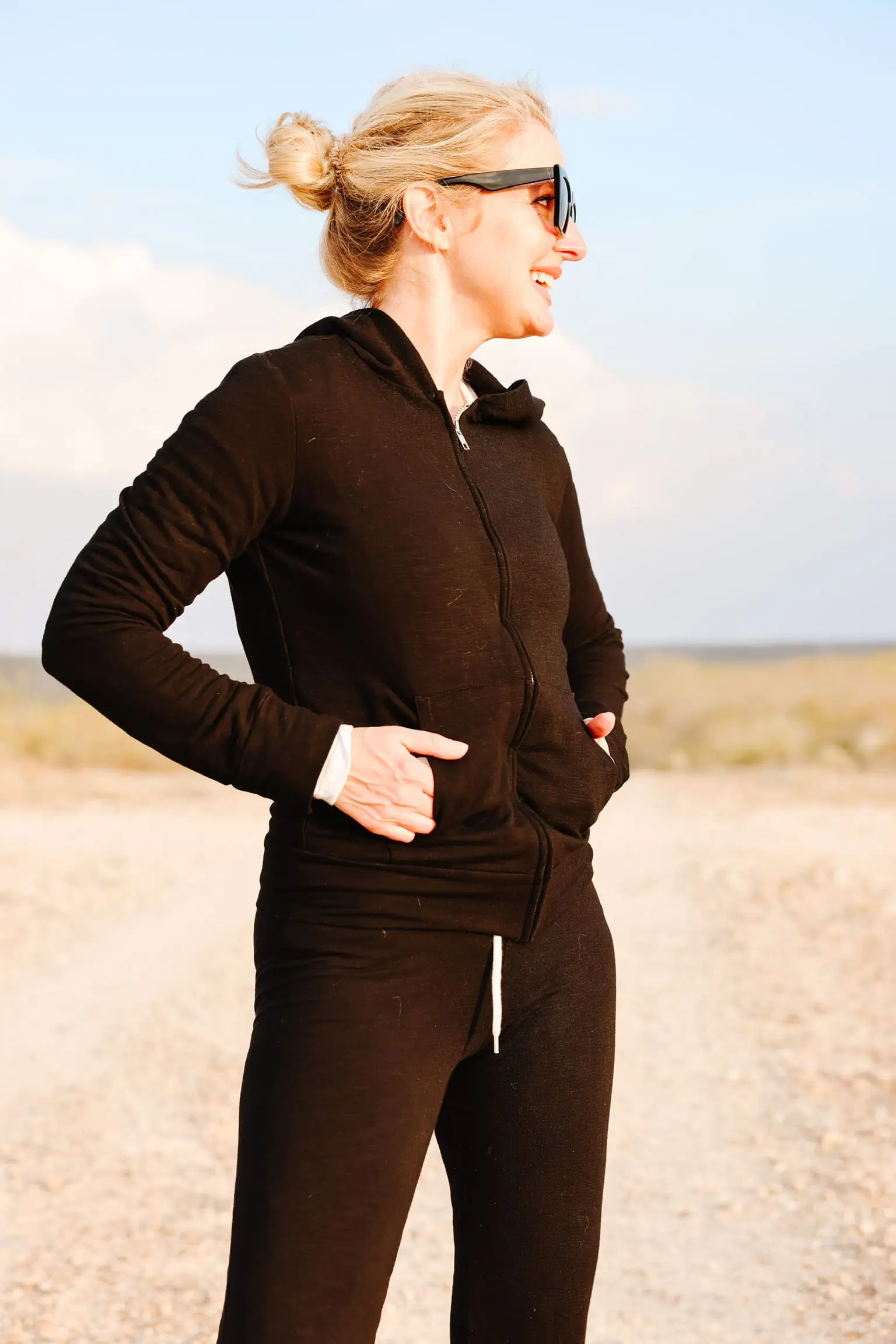 Cozy Loungewear, Erin Busbee of Busbee wearing a black hoodie by Monrow over a white long sleeve tee by Free People tucked into black drawstring joggers by Monrow and black Golden Goose sneakers in south Texas