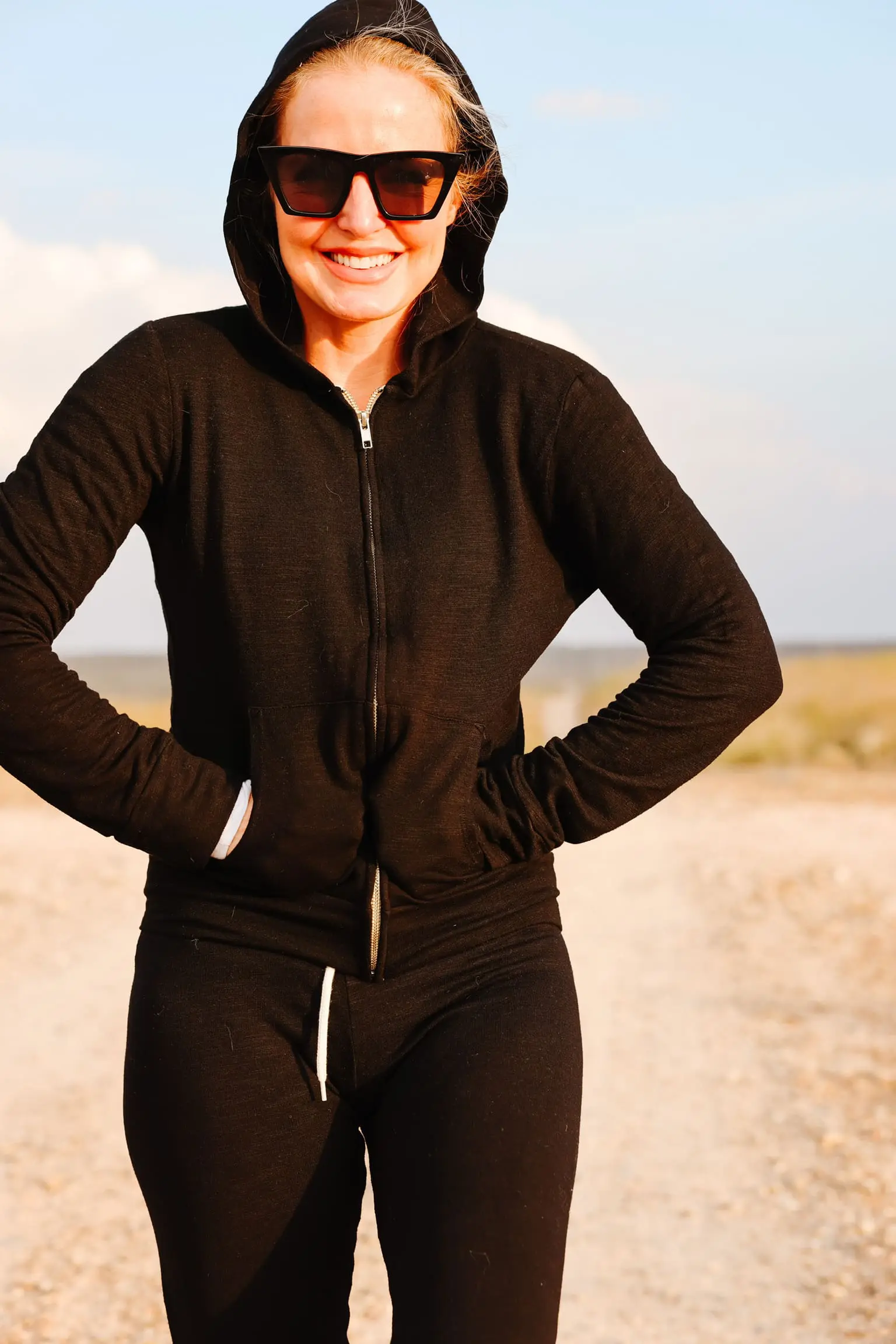 Cozy Loungewear, Erin Busbee of Busbee wearing a black hoodie by Monrow over a white long sleeve tee by Free People tucked into black drawstring joggers by Monrow and black Golden Goose sneakers in south Texas