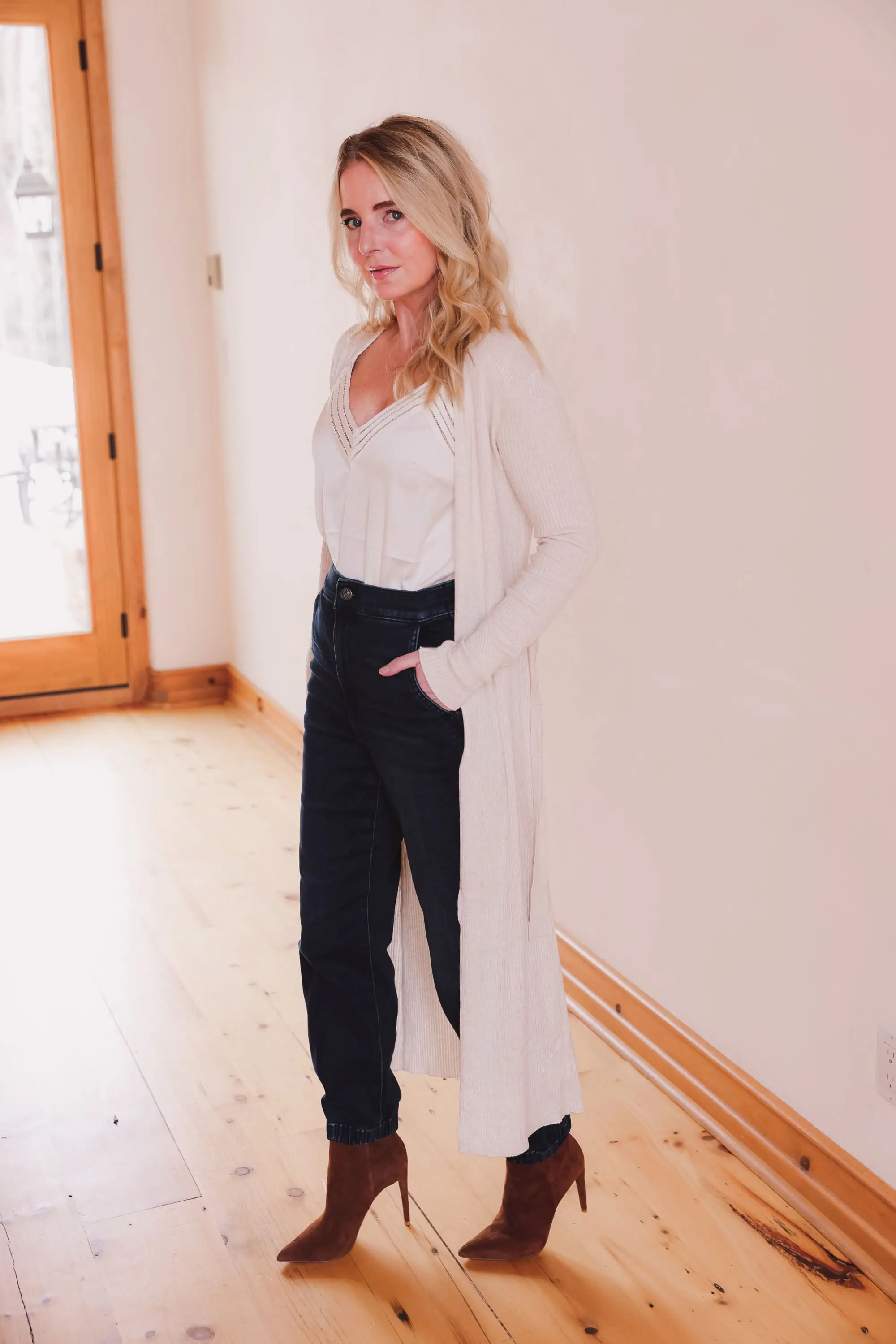 Express Sale, Erin Busbee of Busbee wearing denim joggers, a white satin cami, and long ribbed duster cardigan from Express with Steve Madden brown booties in Telluride, Colorado