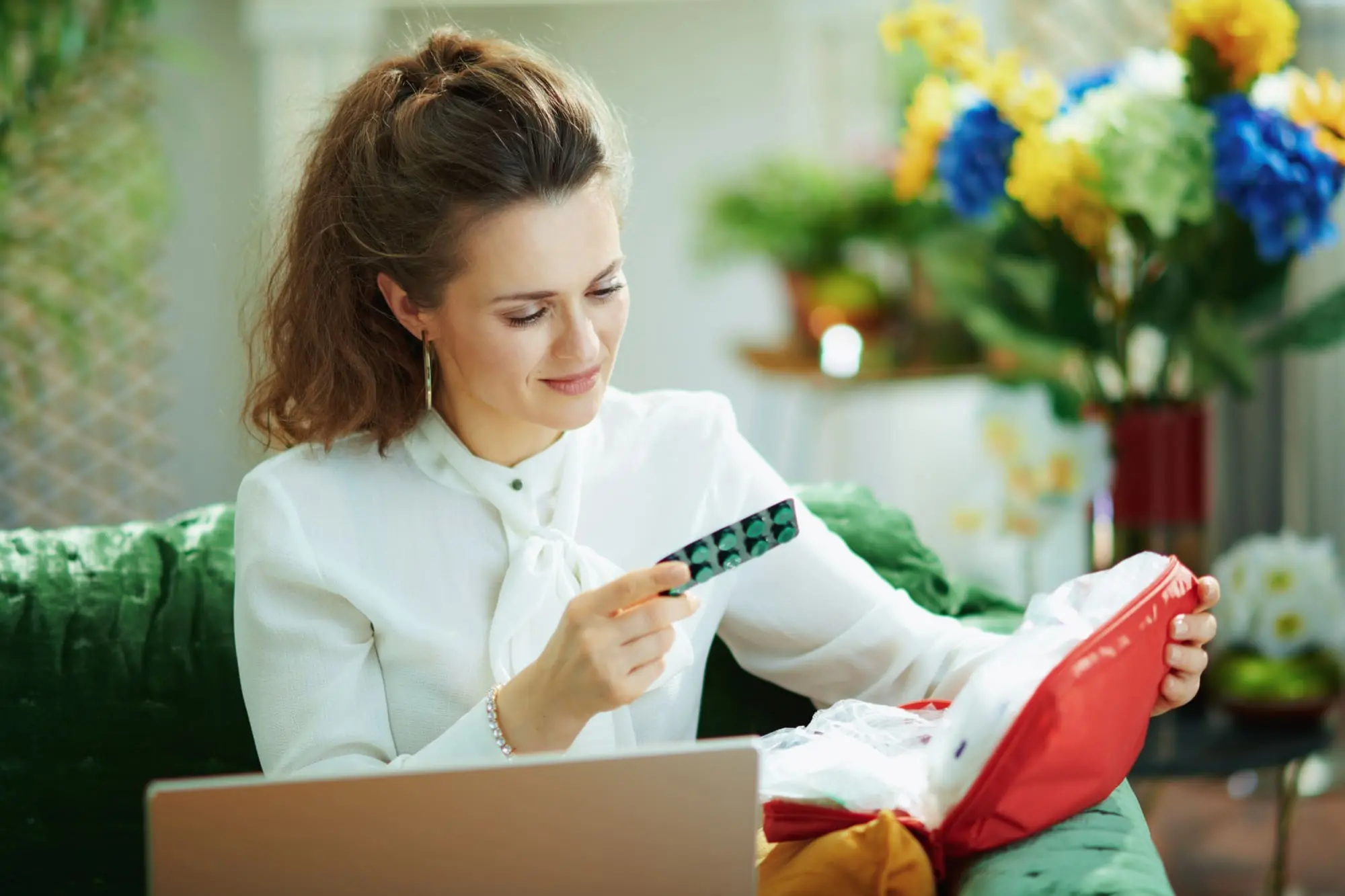 better sex after menopause, Brunette woman in white blouse checking medication at laptop
