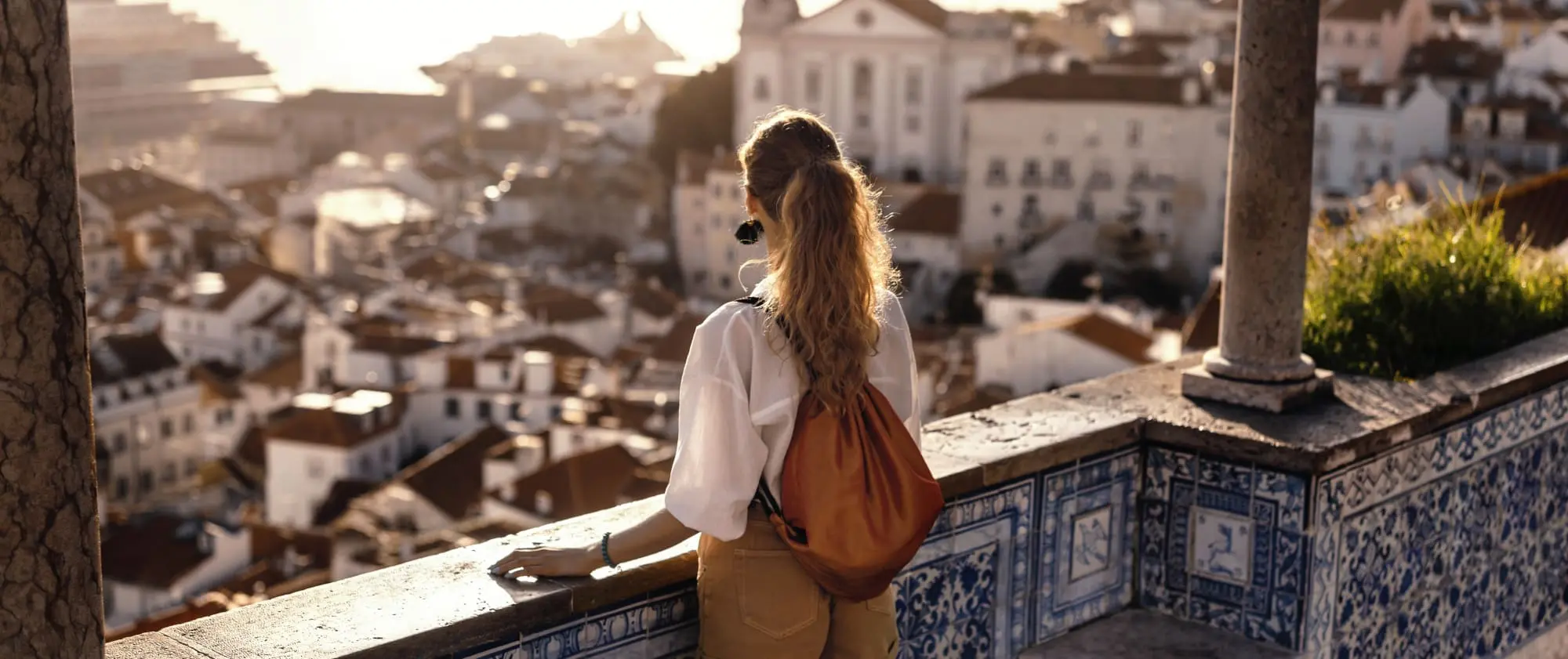 what is neuroplasticity? How to build your brain, Long haired ponytailed woman with leather backpack on tiled balcony overlooking city