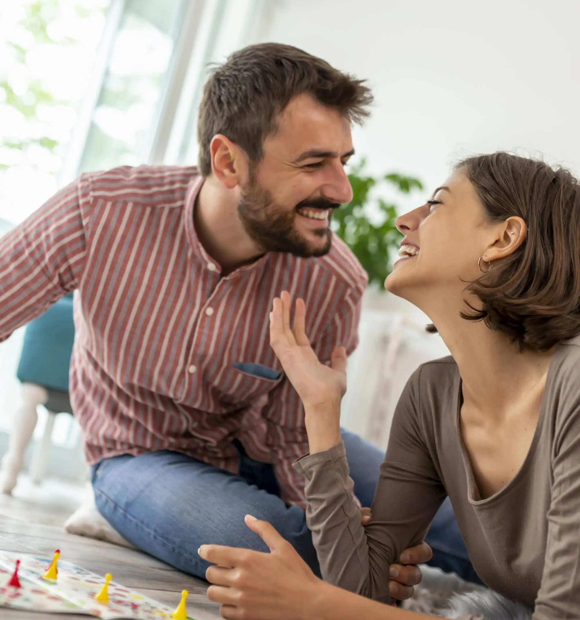 board games for date night, couple laughing having fun playing board game