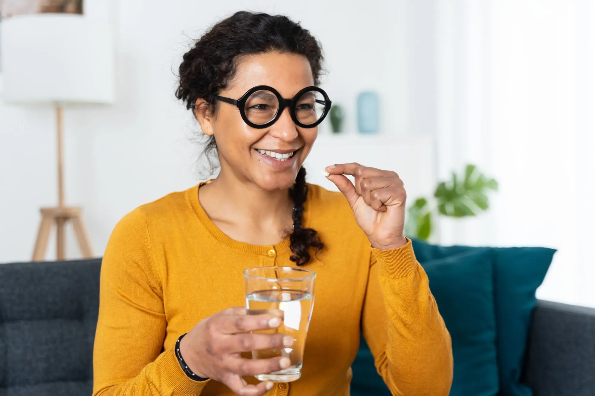 Going Through Menopause? You Should Try Vitamin K2, African American woman holding medicine pills in hand