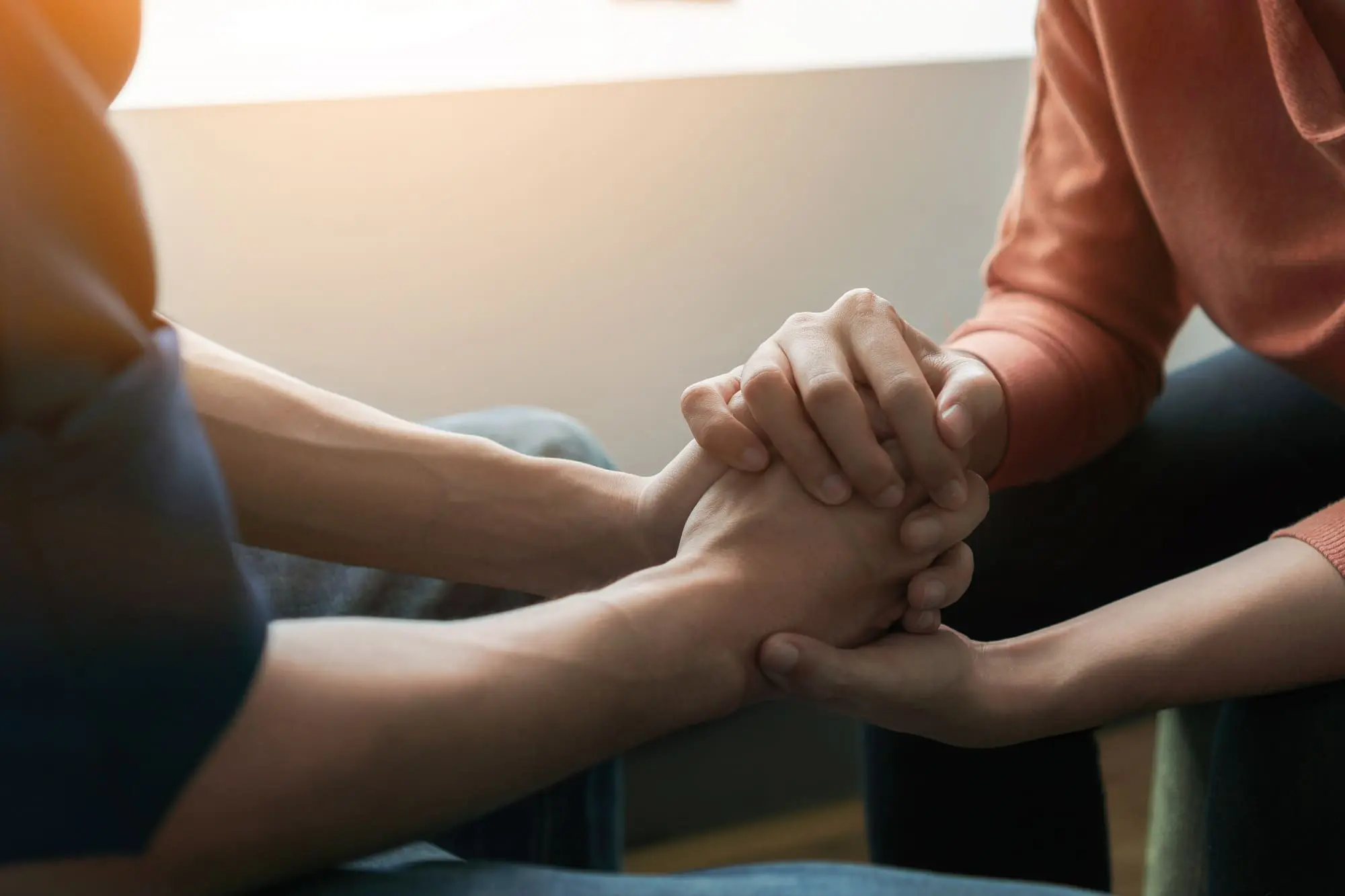fighting fairly in your relationship, couple sitting together holding hands
