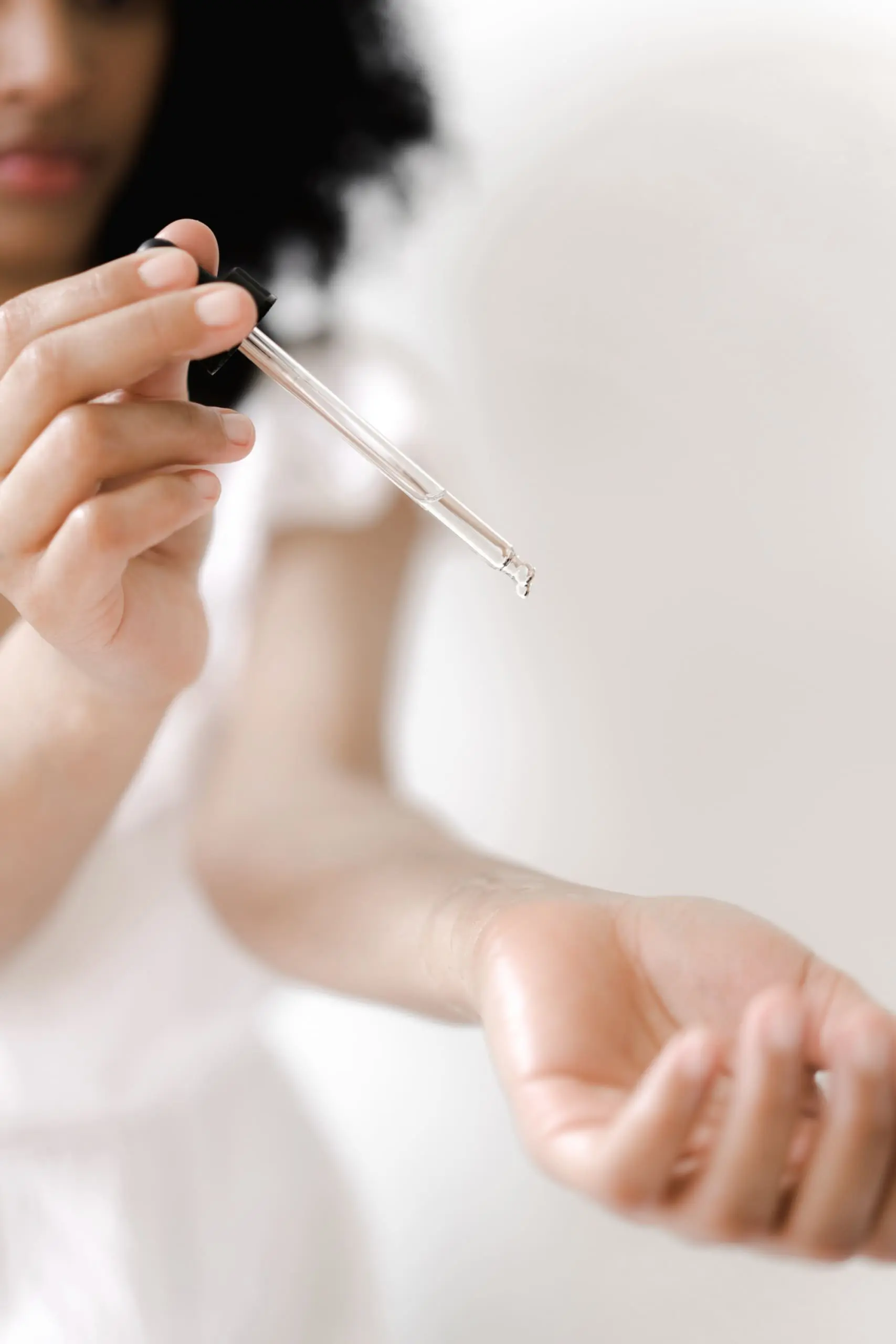 common menopause questions, Black Woman Using Essential Oils on Wrist