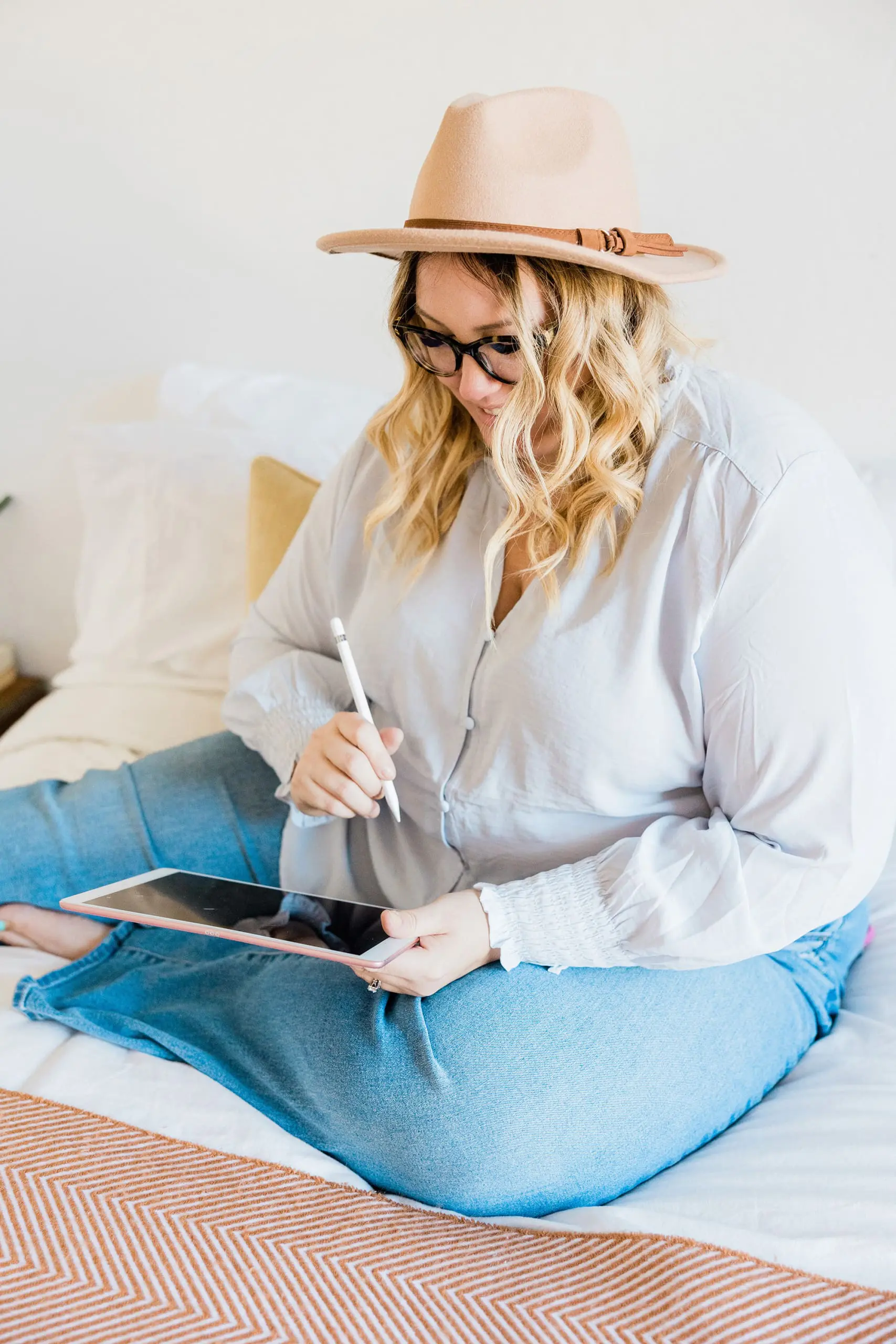 common menopause questions, Blonde wavy-haired woman in hat writing on iPad