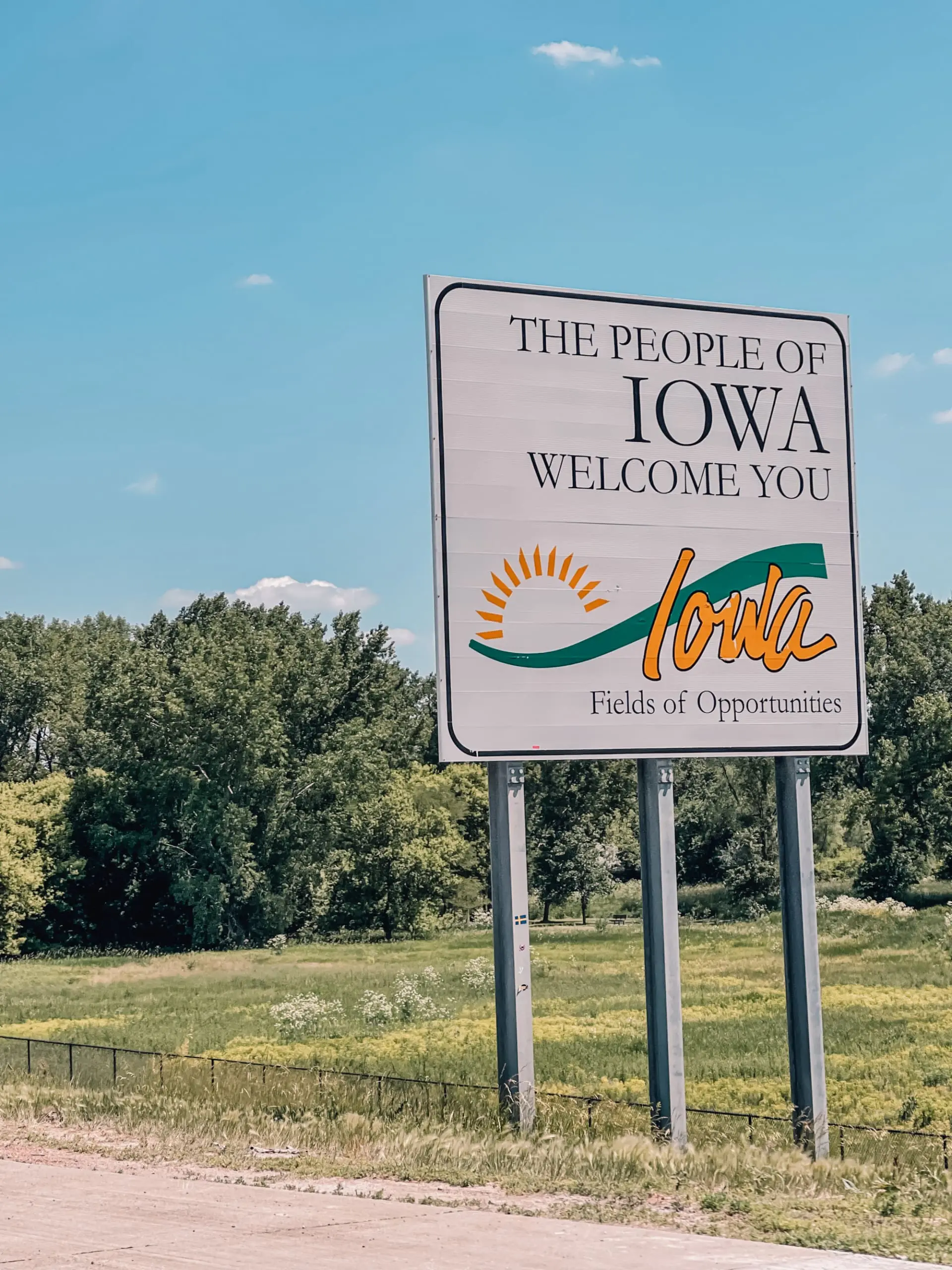 where to stop on a cross-country road trip, best places to stop on a cross country road trip, cross country road trip, west coast to east coast road trip, erin busbee, traveling with kids, how to travel with kids, how to travel with a dog, cross country road trip with kids, iowa state line welcome sign, cross country busbee style, family road trip