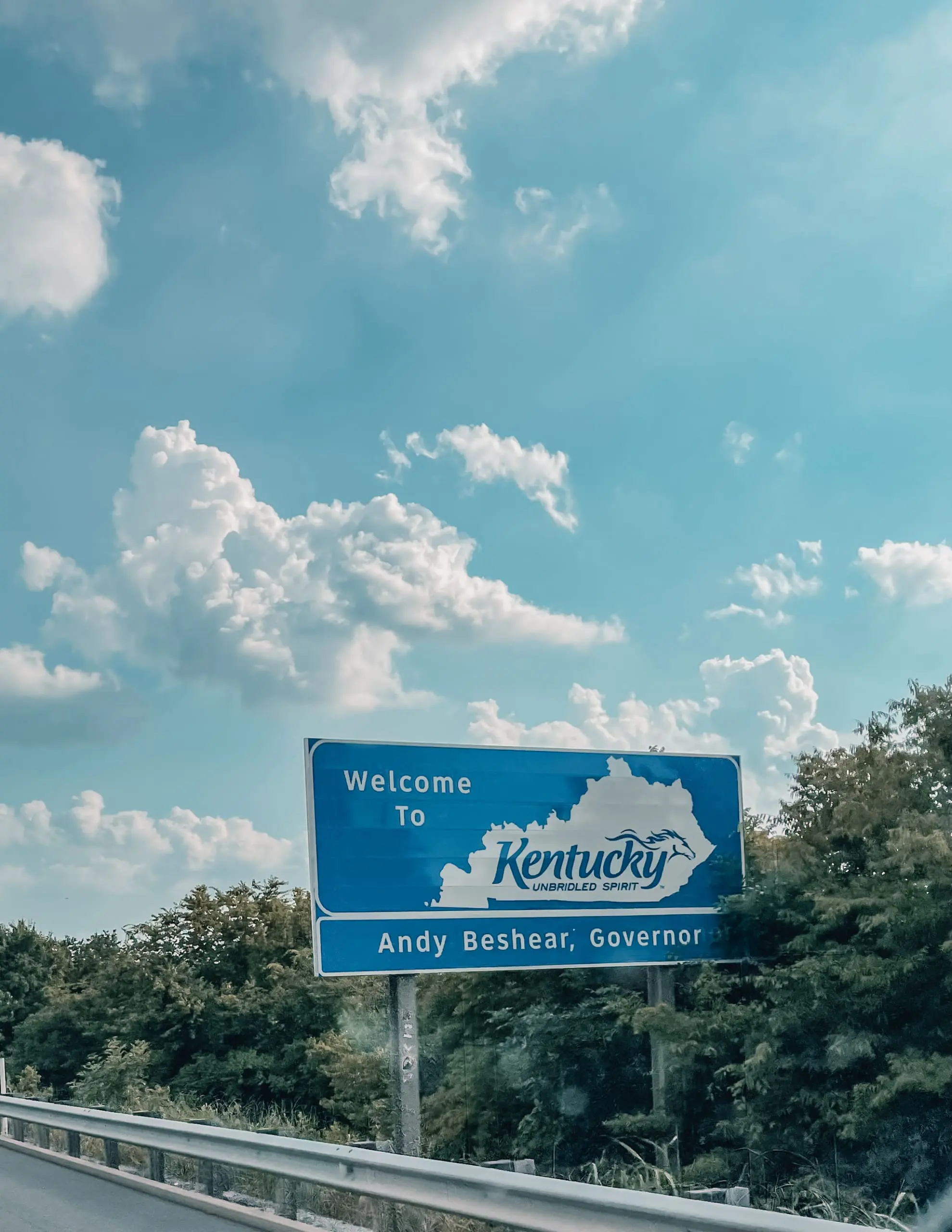 where to stop on a cross-country road trip, best places to stop on a cross country road trip, cross country road trip, west coast to east coast road trip, erin busbee, traveling with kids, how to travel with kids, how to travel with a dog, cross country road trip with kids, kentucky state line welcome sign, cross country busbee style, family road trip