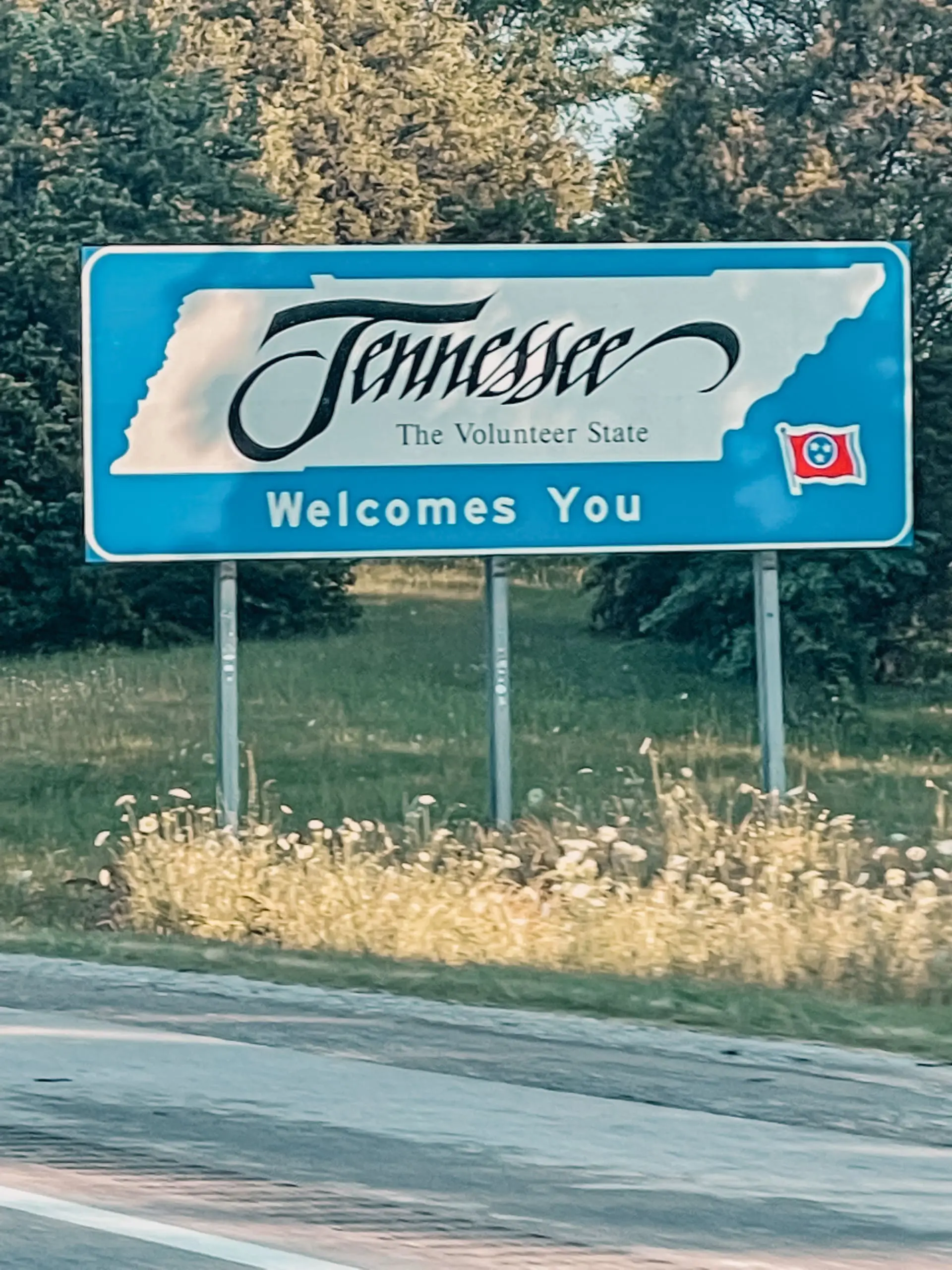 where to stop on a cross-country road trip, best places to stop on a cross country road trip, cross country road trip, west coast to east coast road trip, erin busbee, traveling with kids, how to travel with kids, how to travel with a dog, cross country road trip with kids, tennessee state line welcome sign, cross country busbee style, family road trip