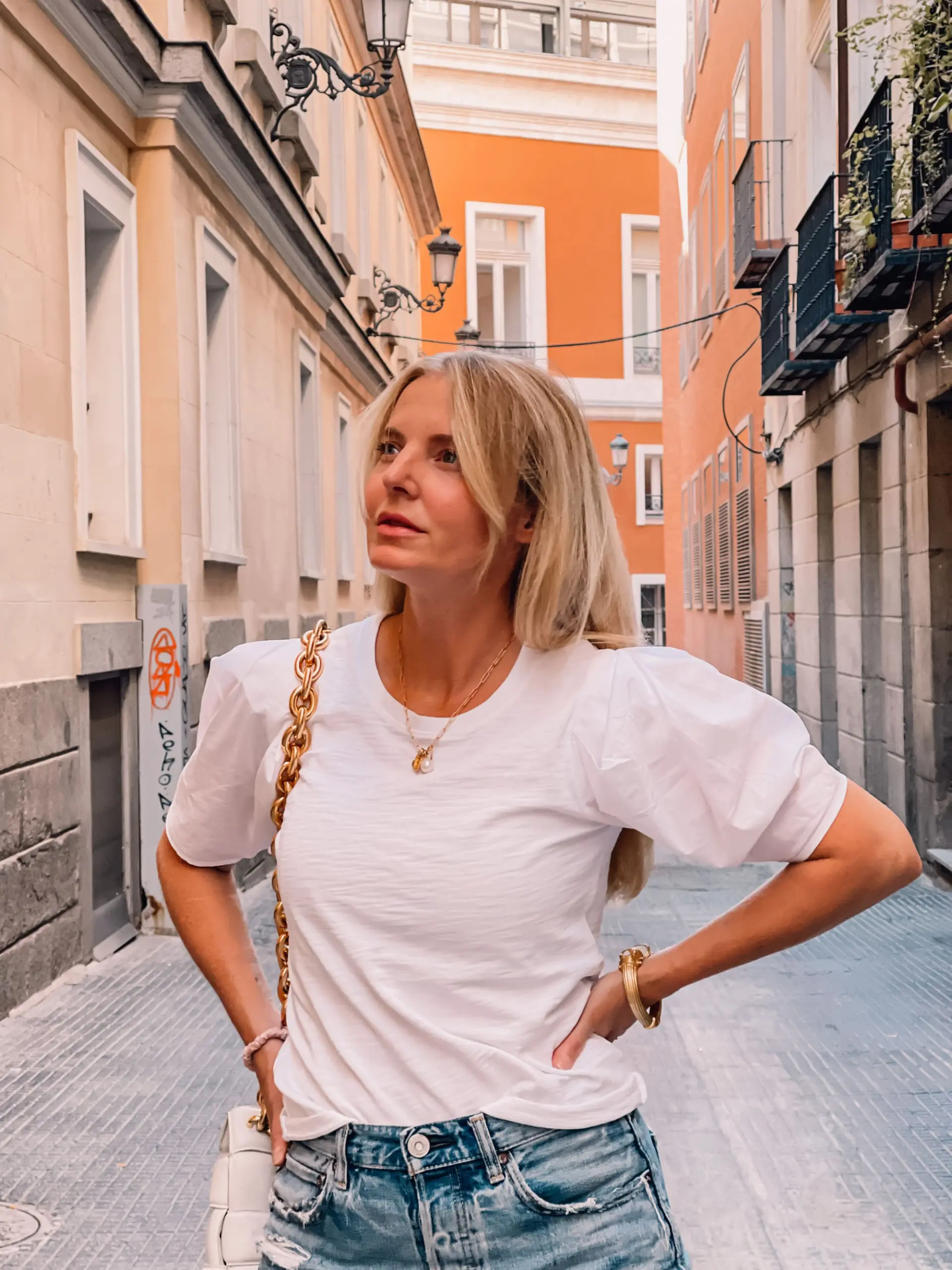 what to wear in spain, how to dress in spain, madrid, how to dress in madrid, what to wear in madrid, how to pack for a trip to spain, trip to spain, packing for spain, erin busbee, nation ltd white puff sleeve tee, moussy vintage denim shorts, bottega veneta chain cassette bag, monica vinader jewelry
