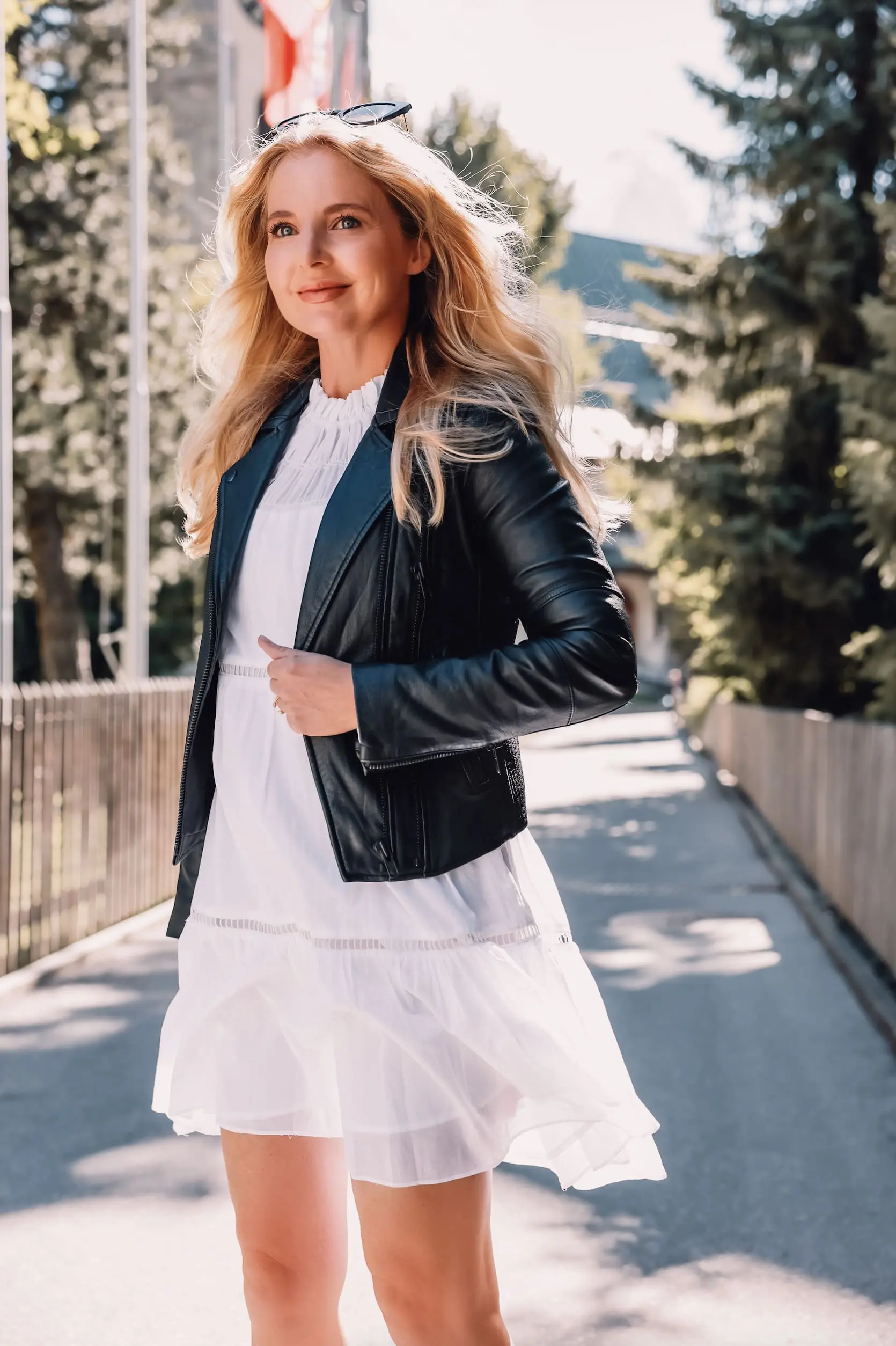 ways to wear a moto jacket, how to wear a moto jacket, moto jackets over 40, how to wear a moto jacket over 40, wearing moto jackets, how to style a moto jacket over 40, erin busbee, black leather moto jacket, white michael kors dress, black Paige side zip booties, zermatt switzerland