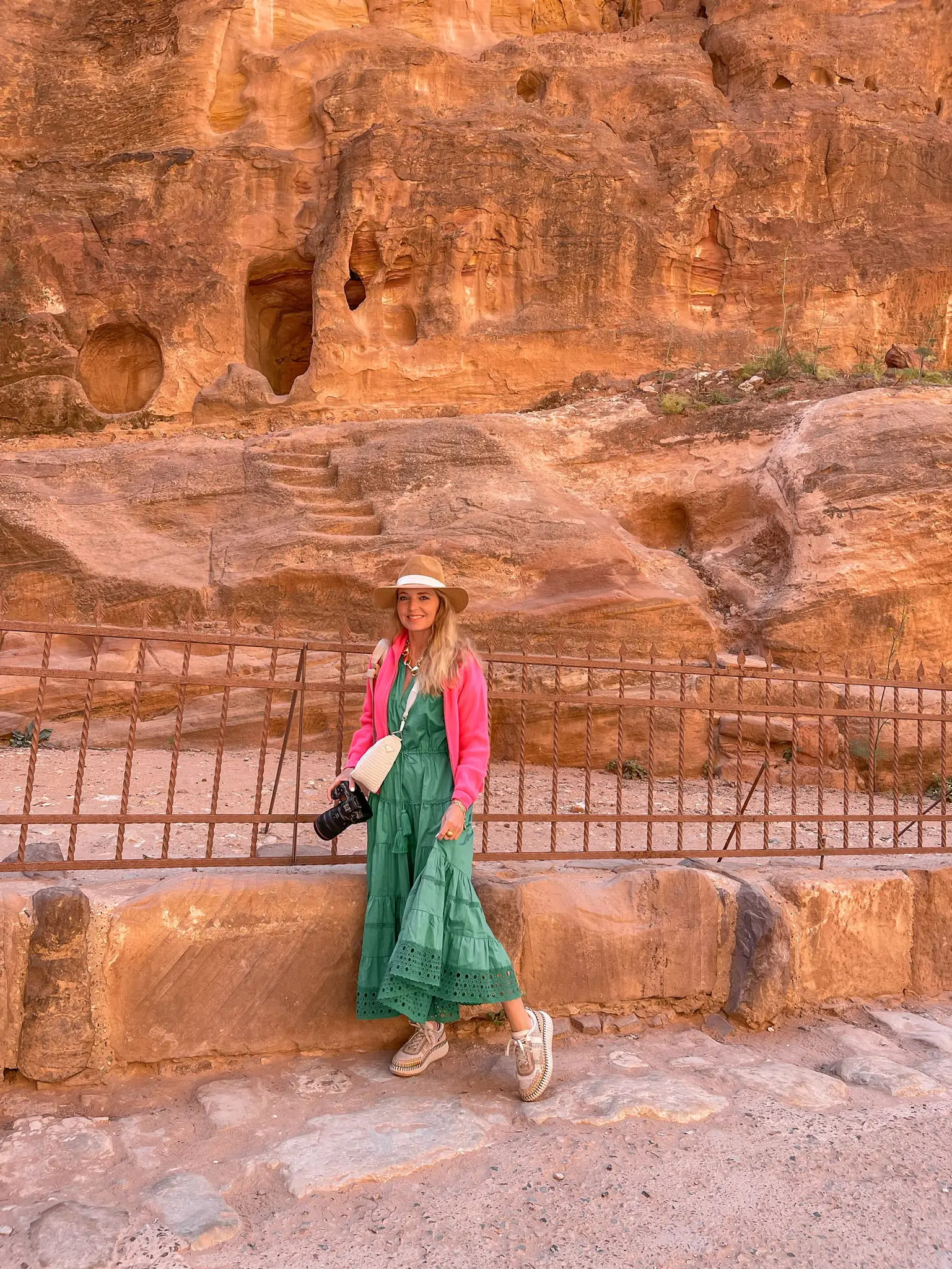 how to dress in middle east, womens dress code in middle east, middle eastern dress female, how to blend in in the middle east, shoes to wear in middle east, what to wear in middle east, how to look stylish in middle east, erin busbee, busbee style, brodie pink cashmere sweater, green Alexis cotton midid dress, chloe sneakers, hariatt isles hat, prada raffia bag, petra, jordan