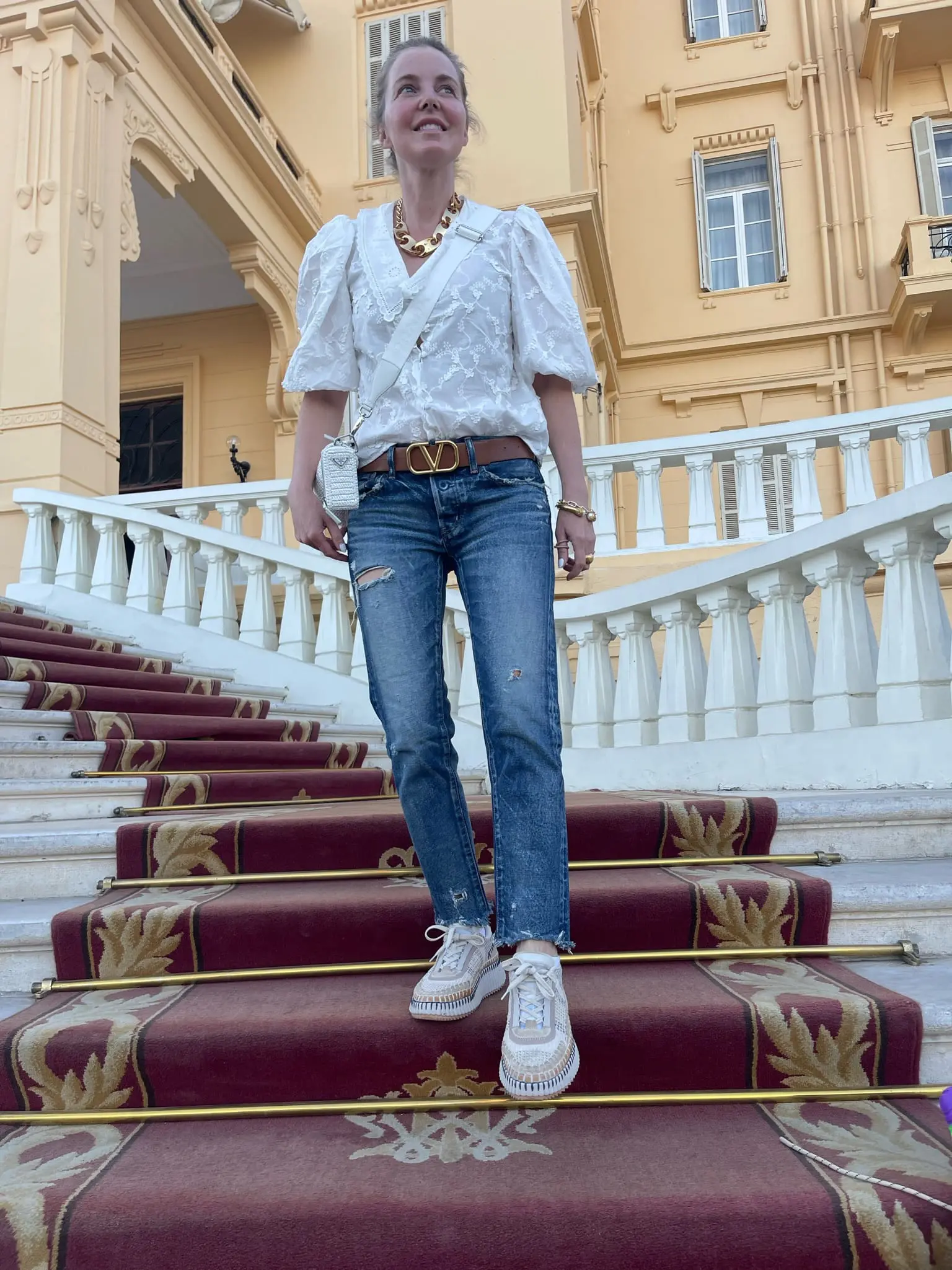 how to dress in middle east, womens dress code in middle east, middle eastern dress female, how to blend in in the middle east, shoes to wear in middle east, what to wear in middle east, how to look stylish in middle east, erin busbee, busbee style, white maje eyelt blouse, moussy vintage jeans, prada raffia bag, chloe stitched sneakers, paco rabbane chain necklace, valentino belt