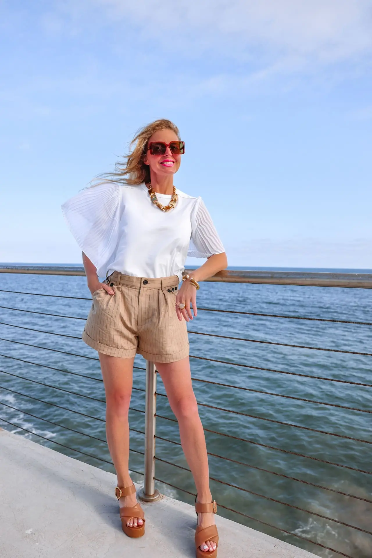 how to wear shorts over 40, best shorts for women over 40, how to wear shorts over 50, flattering shorts for women over 40, best shorts for 40 year old woman, best denim shorts over 40, too old to wear shorts, how to find the perfect shorts, what to wear with shorts, erin busbee, busbee style, malibu, california, marissa webb pinstripe shorts, white see by chloe pleat sleeve top, see by chloe platform heels, saint laurent sunglasses