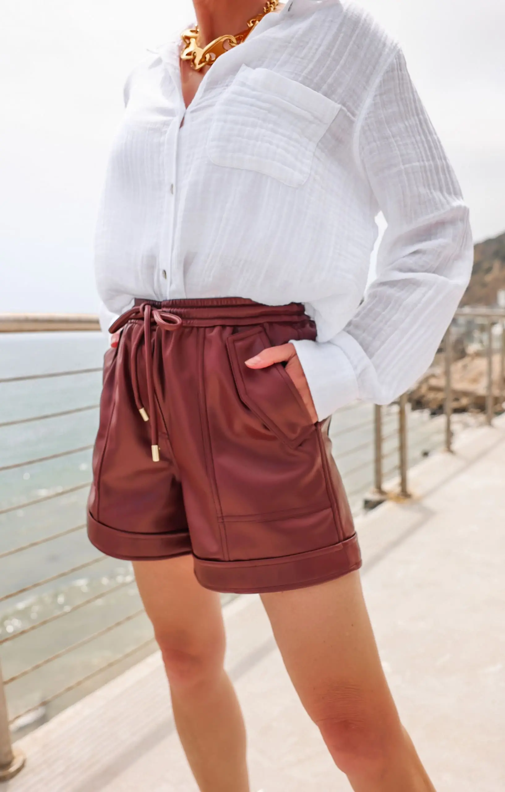 how to wear shorts over 40, best shorts for women over 40, how to wear shorts over 50, flattering shorts for women over 40, best shorts for 40 year old woman, best denim shorts over 40, too old to wear shorts, how to find the perfect shorts, what to wear with shorts, erin busbee, busbee style, malibu, california, brown jonathan simkhai vegan leather shirts, white rails cotton button down shirt, veronica beard woven sandals, saint laurent sunglasses