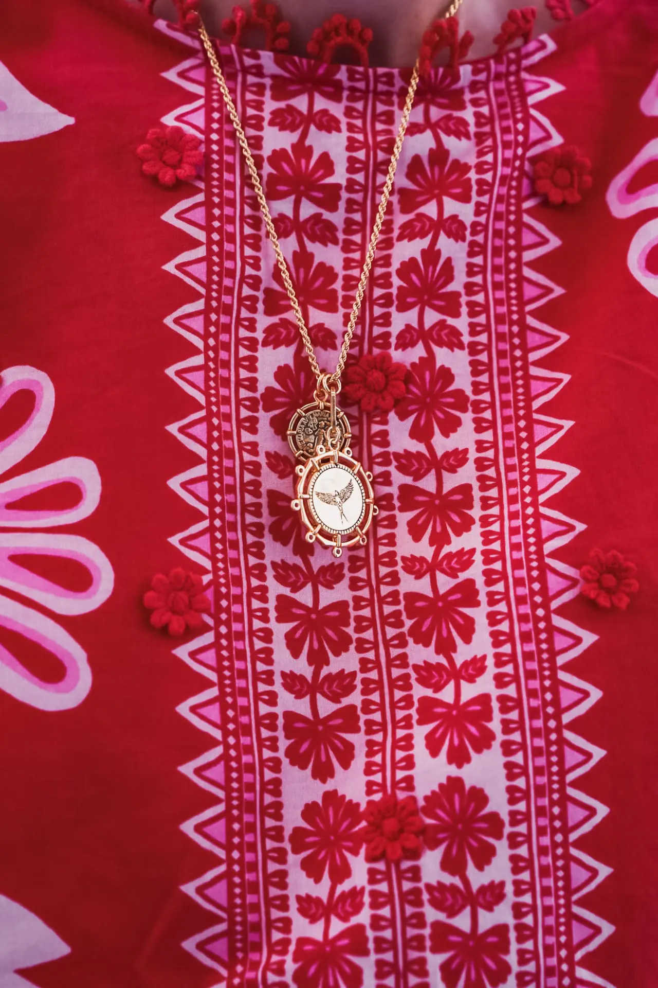 red top and gold necklace