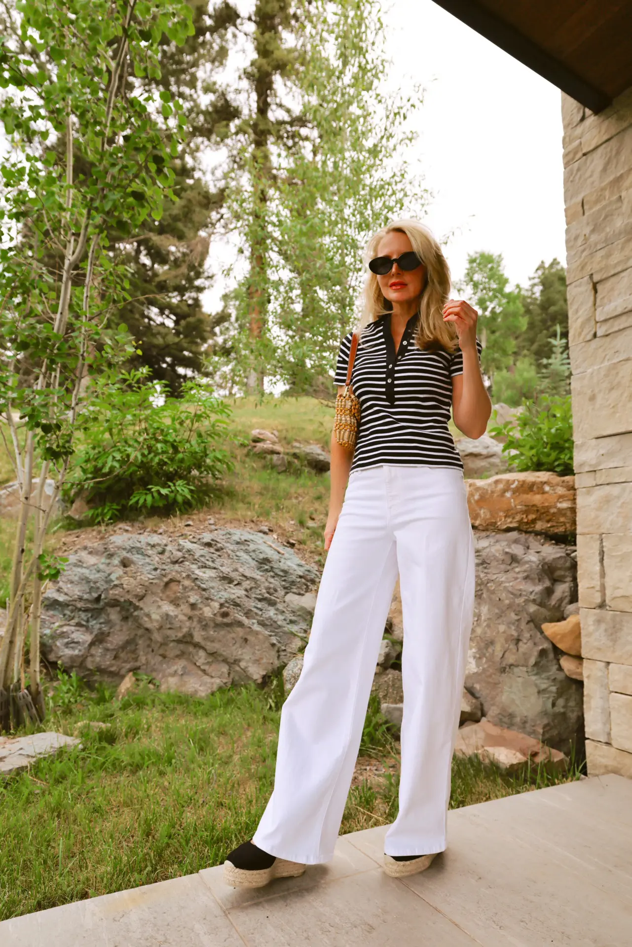 viral east coast summer style trend and how to wear it featuring striped polo shirt by Veronica Beard, white wide leg jeans by FRAME, prada triangle scarf in black and white and Staud beaded bag