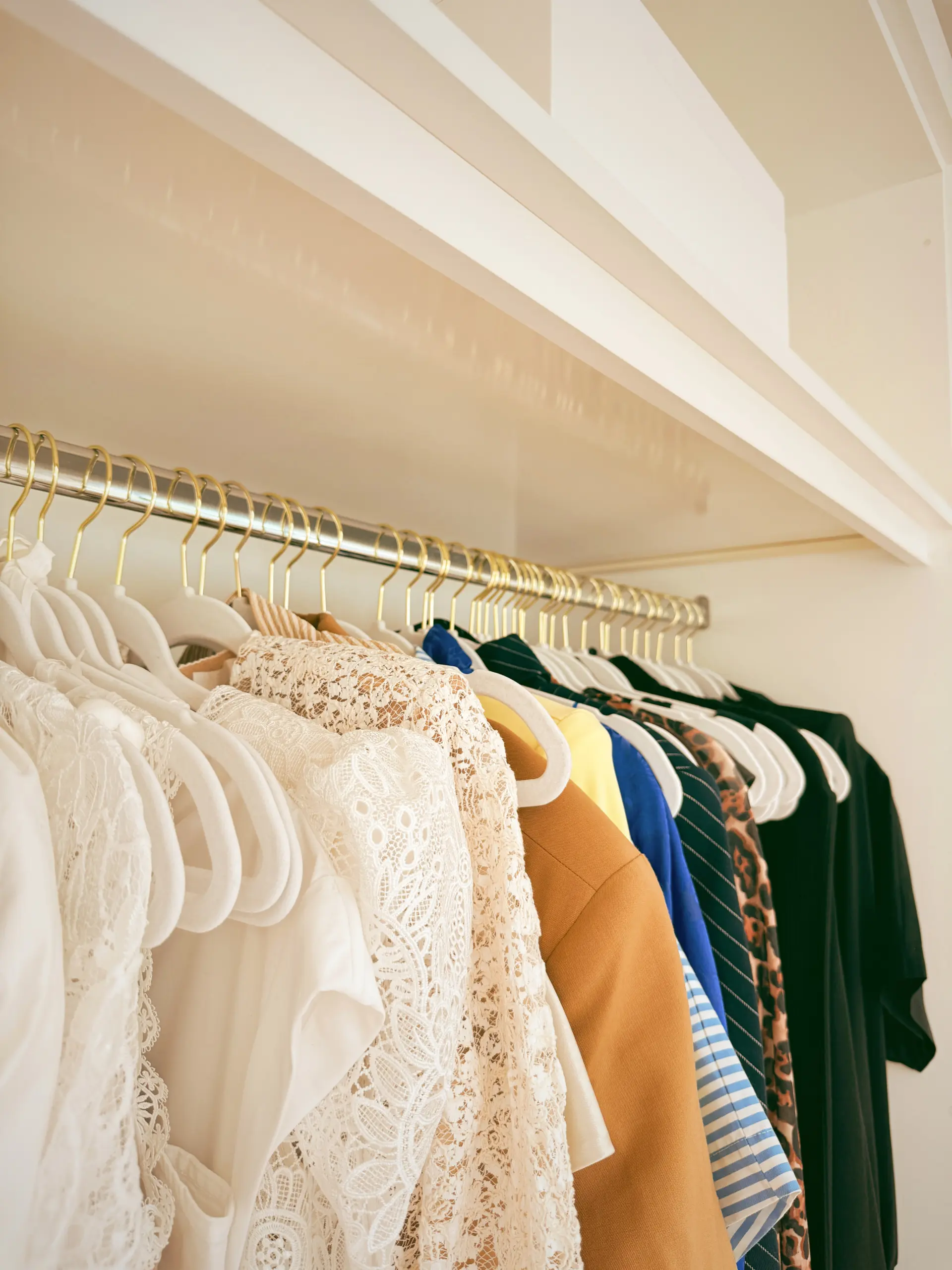 rack of clothes in a closet, choose a color story for packing in a carry on