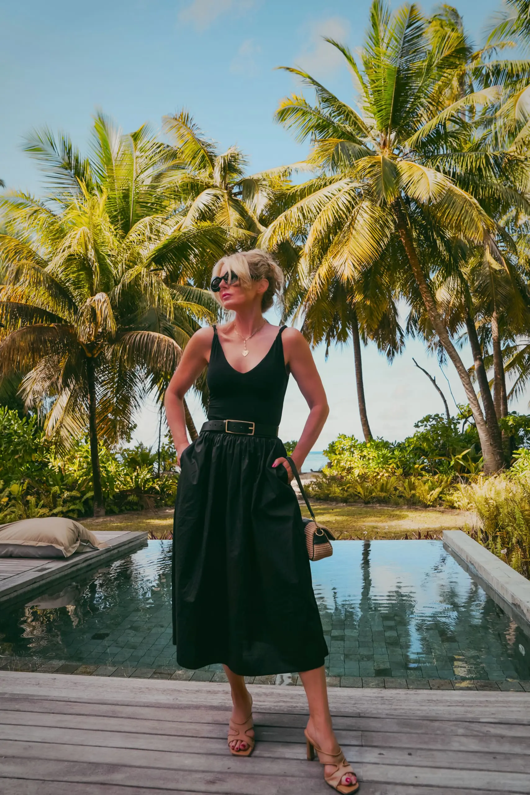 styled black dress for vacation with beige heels and black belt