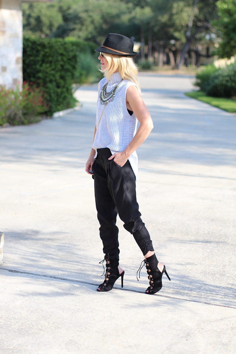 sleeveless sweater and black silky joggers paired with a fedora and black heels