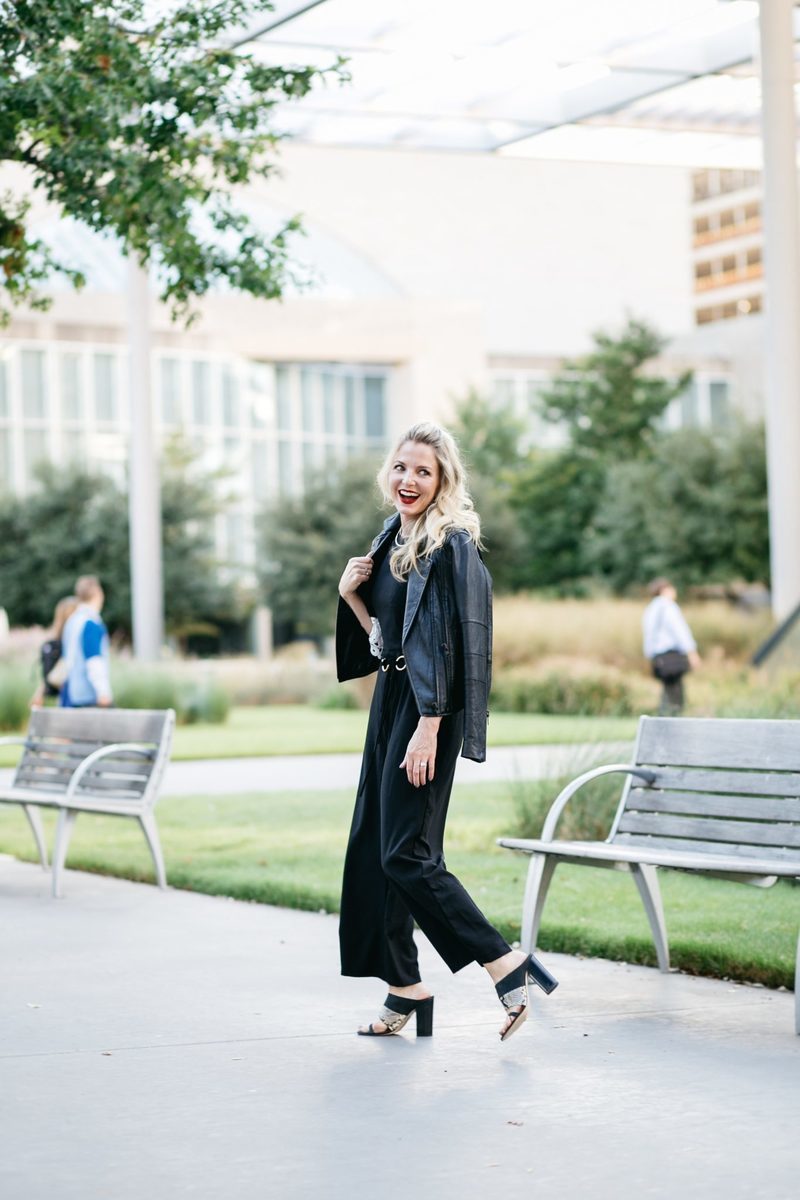 Asks black jumpsuit with a black joie leather moto jacket and m.gemi black and python slides