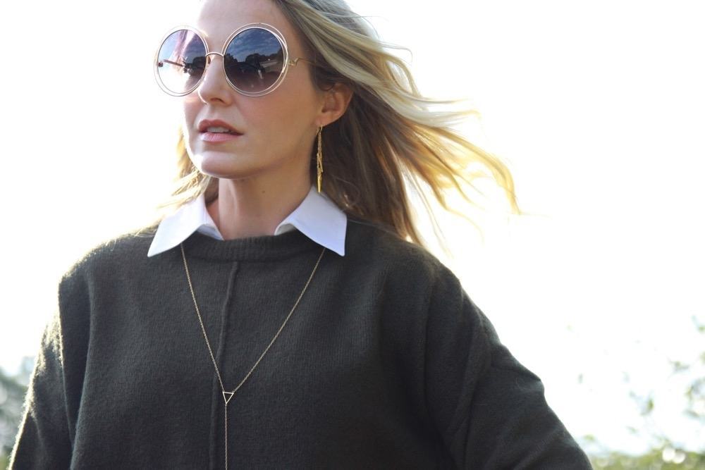 hair blowing in the breeze, erin busbee wearing chloe over-sized round carlina sunglasses, a dark green topshop sweater, layered over a white button down by calvin klein and a gorjana mika lariat necklace