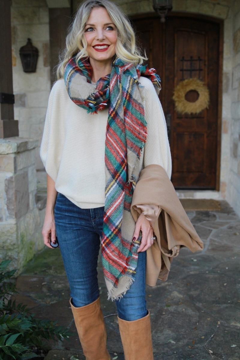 white cashmere sweater by marled by reunited from neiman marcus last call paired with a green and red blanket scarf slung over the shoulder, skinny jeans by ciitzens and tall suede camel boots