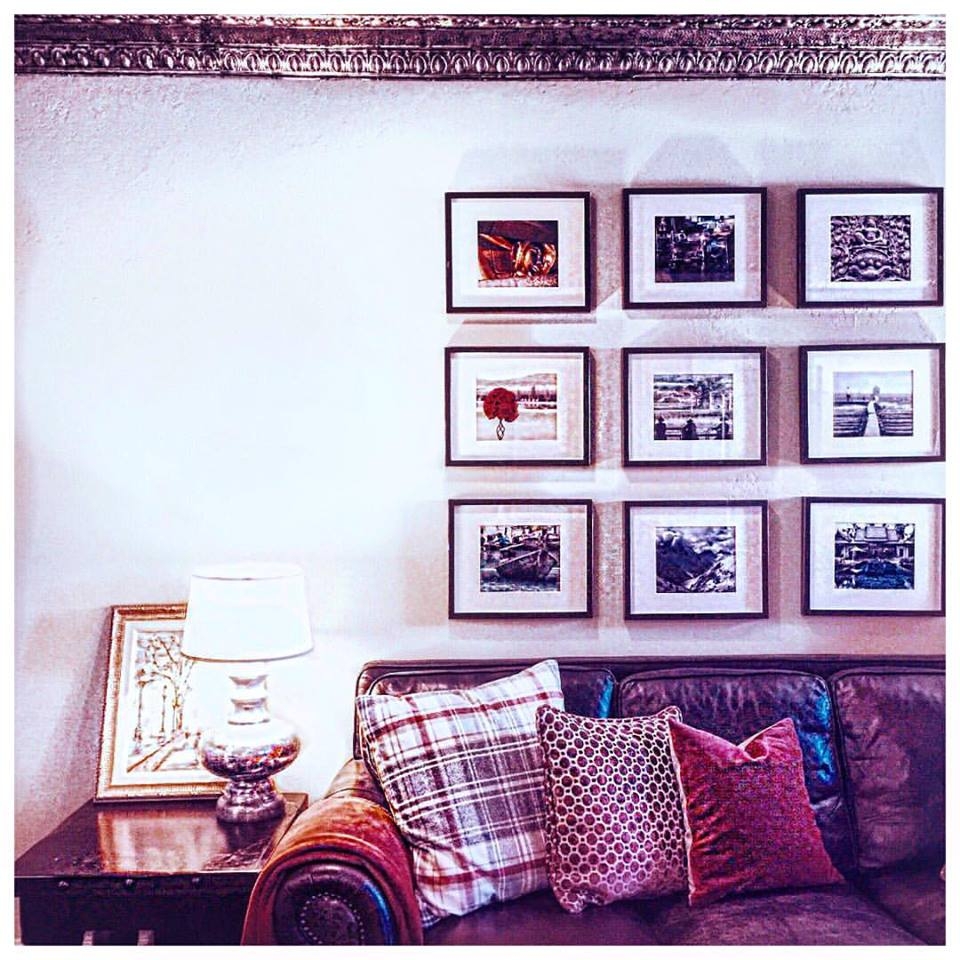 wall gallery and dark leather sofa with plaid pillows 