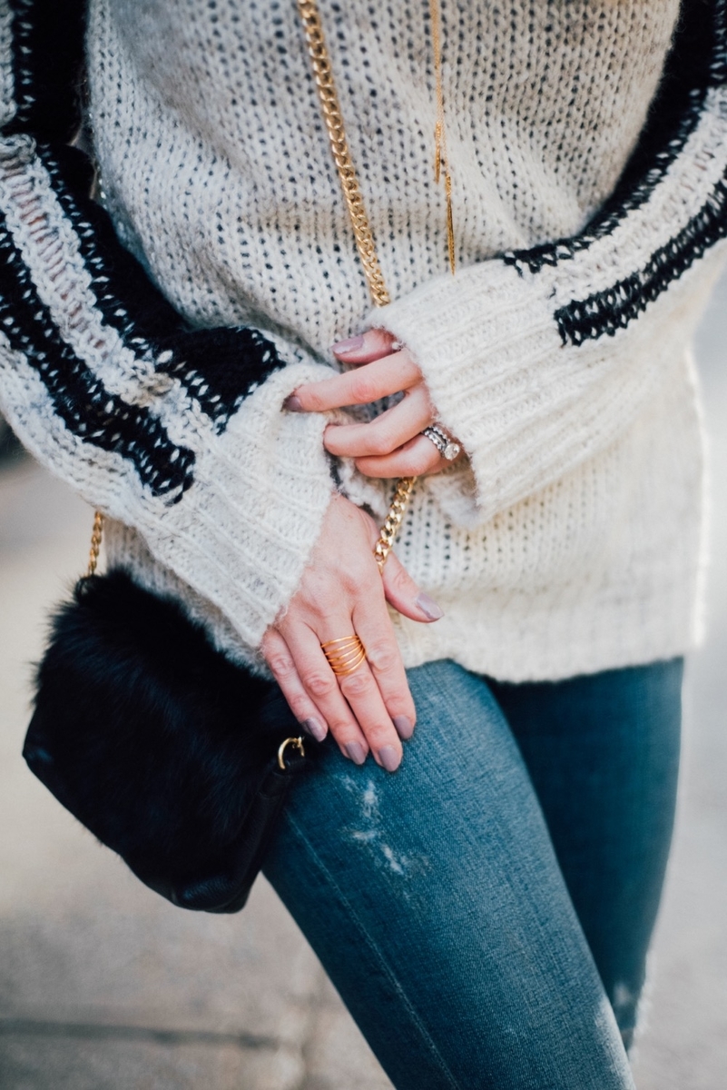 mini crossbody fur bag in black with gorjana carine ring in gold, dark washing skinny jeans by citizens and a striped pam and gela sweater