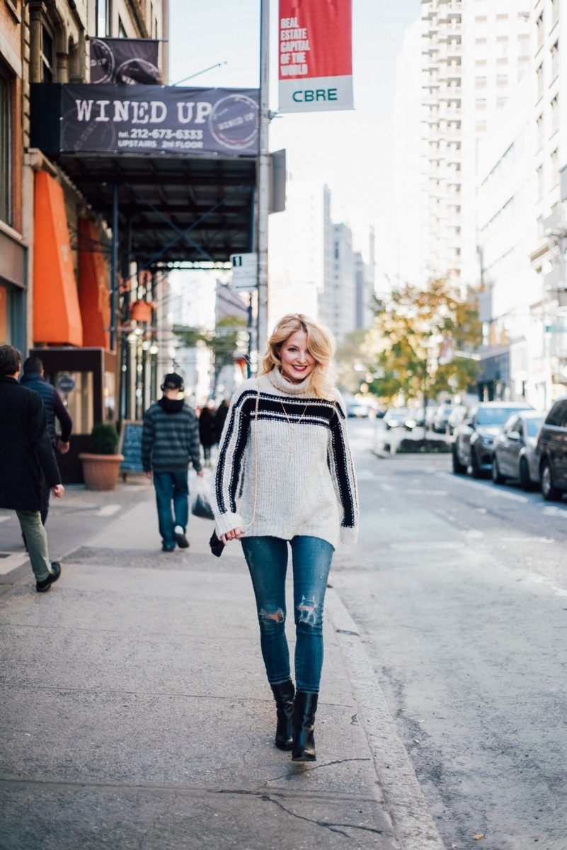 fashion blogger new york city street shot with dark wash skinny jeans by citizens of humanity and mid-calf booties by sam edelman and back zipper detail