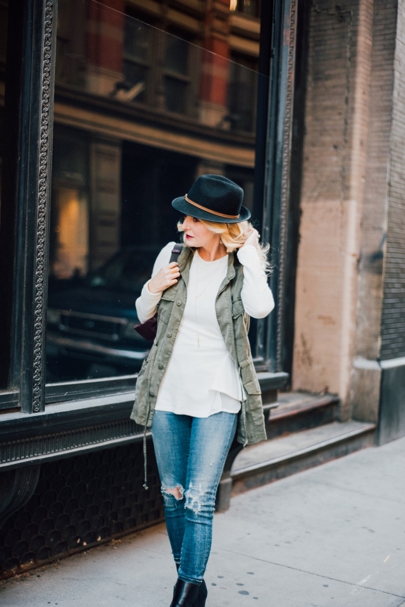 wearing a casual, street chic outfit in new york city, featuring a fedora, cargo vest from target, chicwish white peplum top and citiznens of humanity vintage skinny jeans 