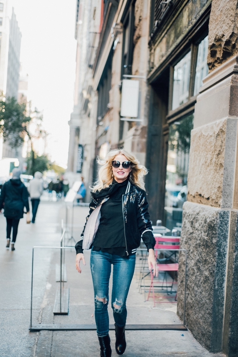 street style shot featuring an outfit idea for a bomber jacket, bb dakota sequin bomber jacket, with vintage, distressed skinny jeans by citizens of humanity and black sam edelman mid-calf booties