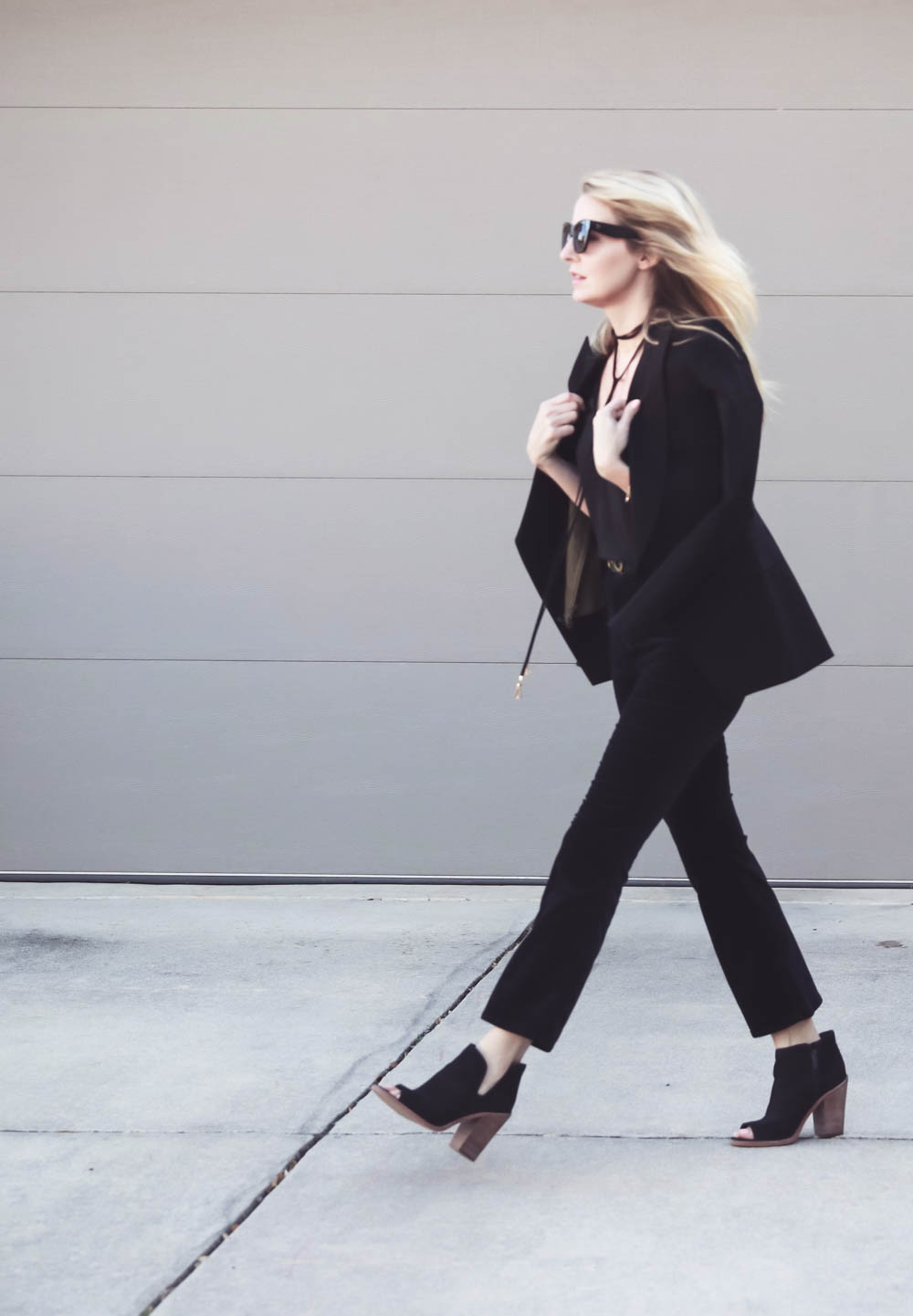 Erin Busbee, fashion blogger and wardrobe stylist from Busbee Style is wearing a Baublebar lariat choker necklace in black paired with a veronica beard scuba blazer and cropped, flared pants by Rag and Bone with Vince Camuto peep toe booties in black. Wear all one color to look longer and taller