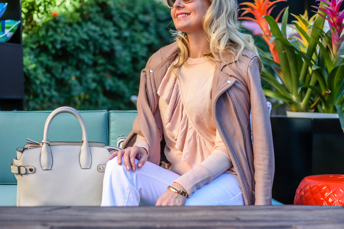 erin busbee from busbeestyle.com in palm springs for alt summit wearing wide leg white jeans, a ruffle peach sweater by topshop and an iro jacket called "Han" in taupe carrying a Henri Bendel handbag in sea salt white