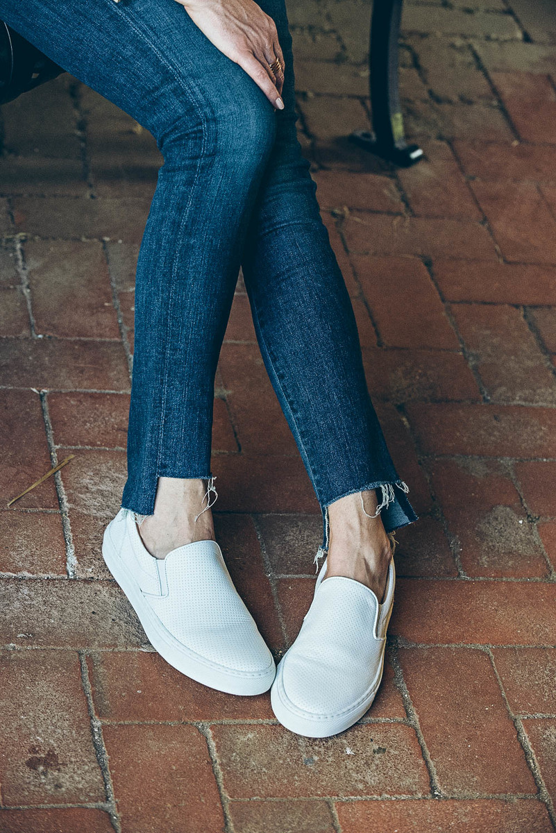 White sneakers slip on by Greats brand, worn 2 ways, including jeans and a one-shoulder top and a beige trench and white eyelet top, featured on Erin Busbee, of BusbeeStyle, fashion blogger and youtuber