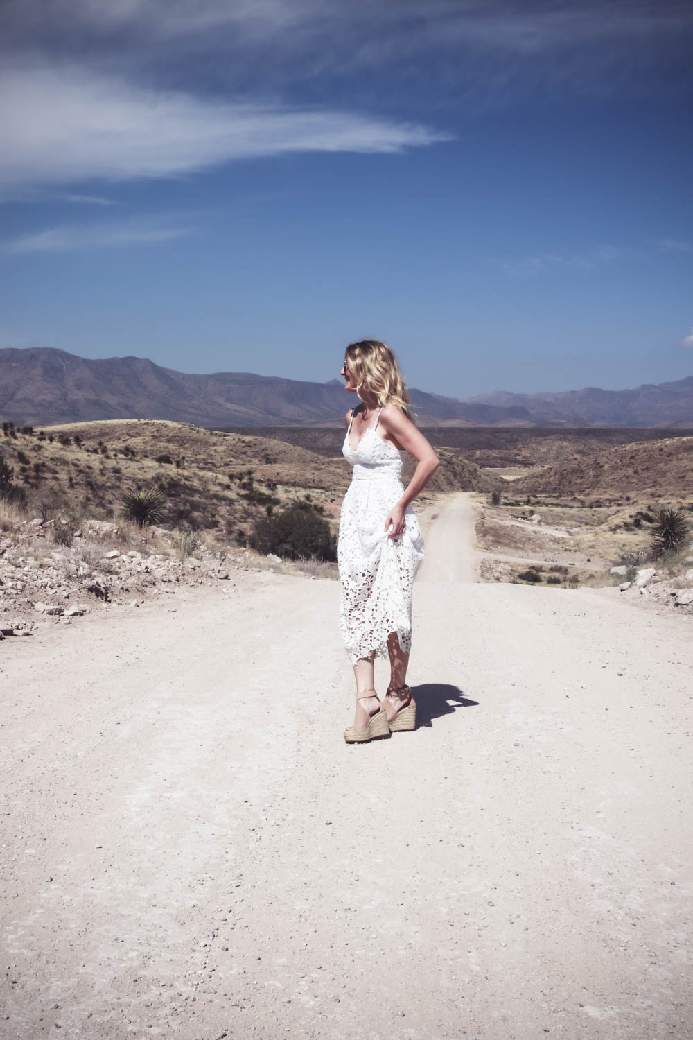Fashion blogger and fashion youtuber, erin busbee of busbeestyle.com, wearing a white lace dress by ASTR, nude leather espadrille sandals by Marc Fisher (super comfortable) and the mirrored aviator sunglasses are by Quay Australia in Marfa Texas 